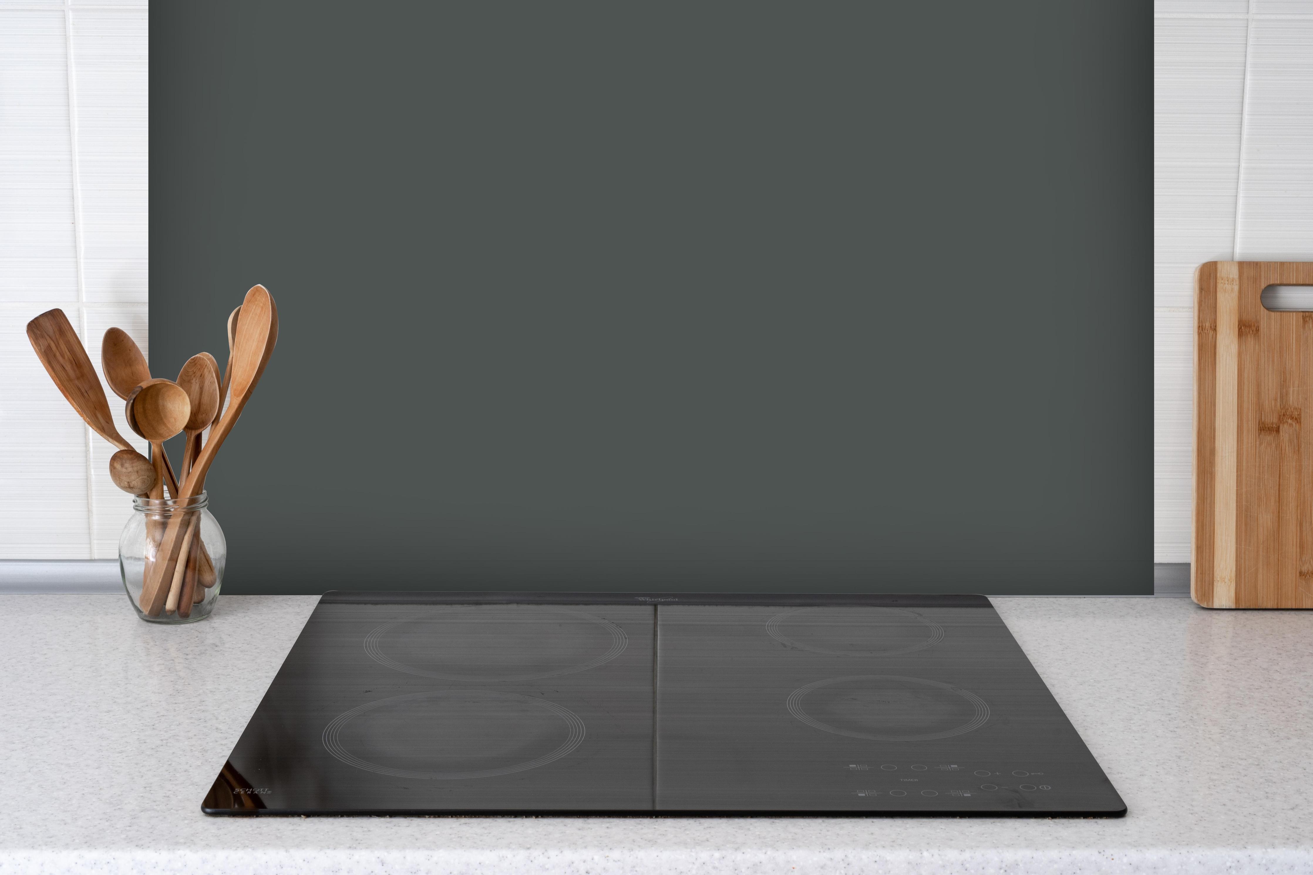 Spritzschutz - RAL 7043 (Verkehrsgrau B) hinter einem Cerankochfeld zwischen Holz-Kochutensilien