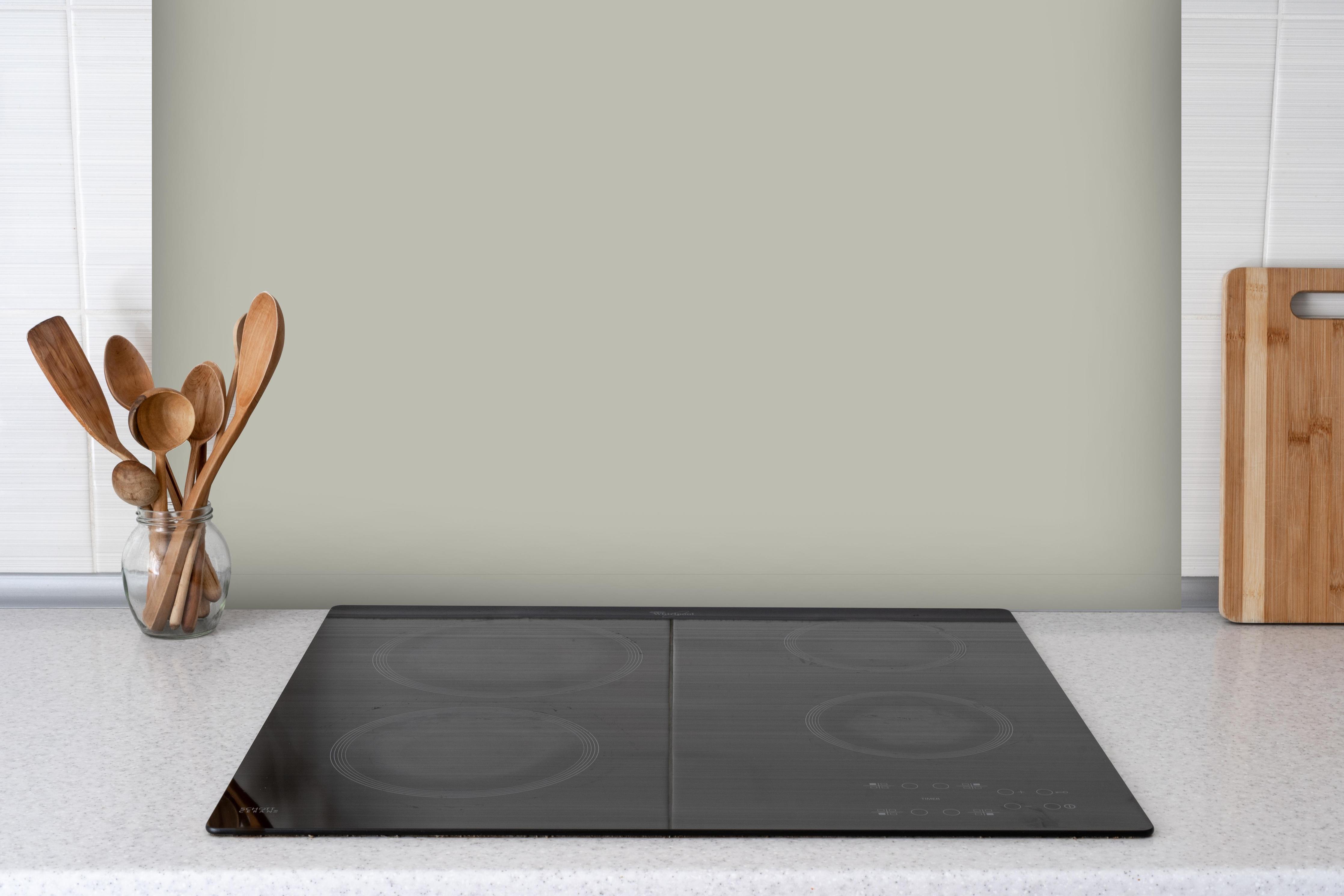Spritzschutz - RAL 7044 (Seidengrau) hinter einem Cerankochfeld zwischen Holz-Kochutensilien