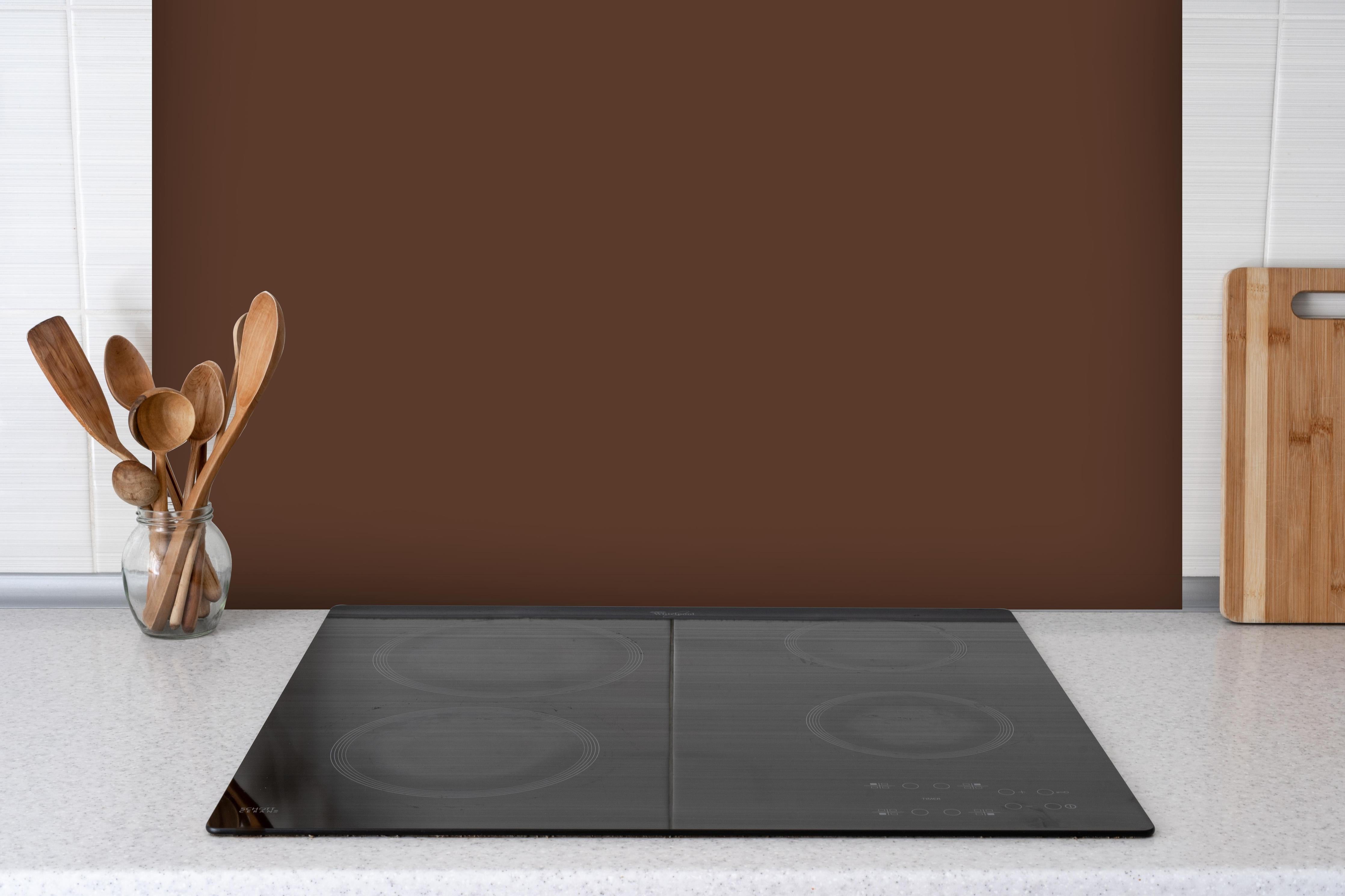 Spritzschutz - RAL 8011 (Nussbraun) hinter einem Cerankochfeld zwischen Holz-Kochutensilien