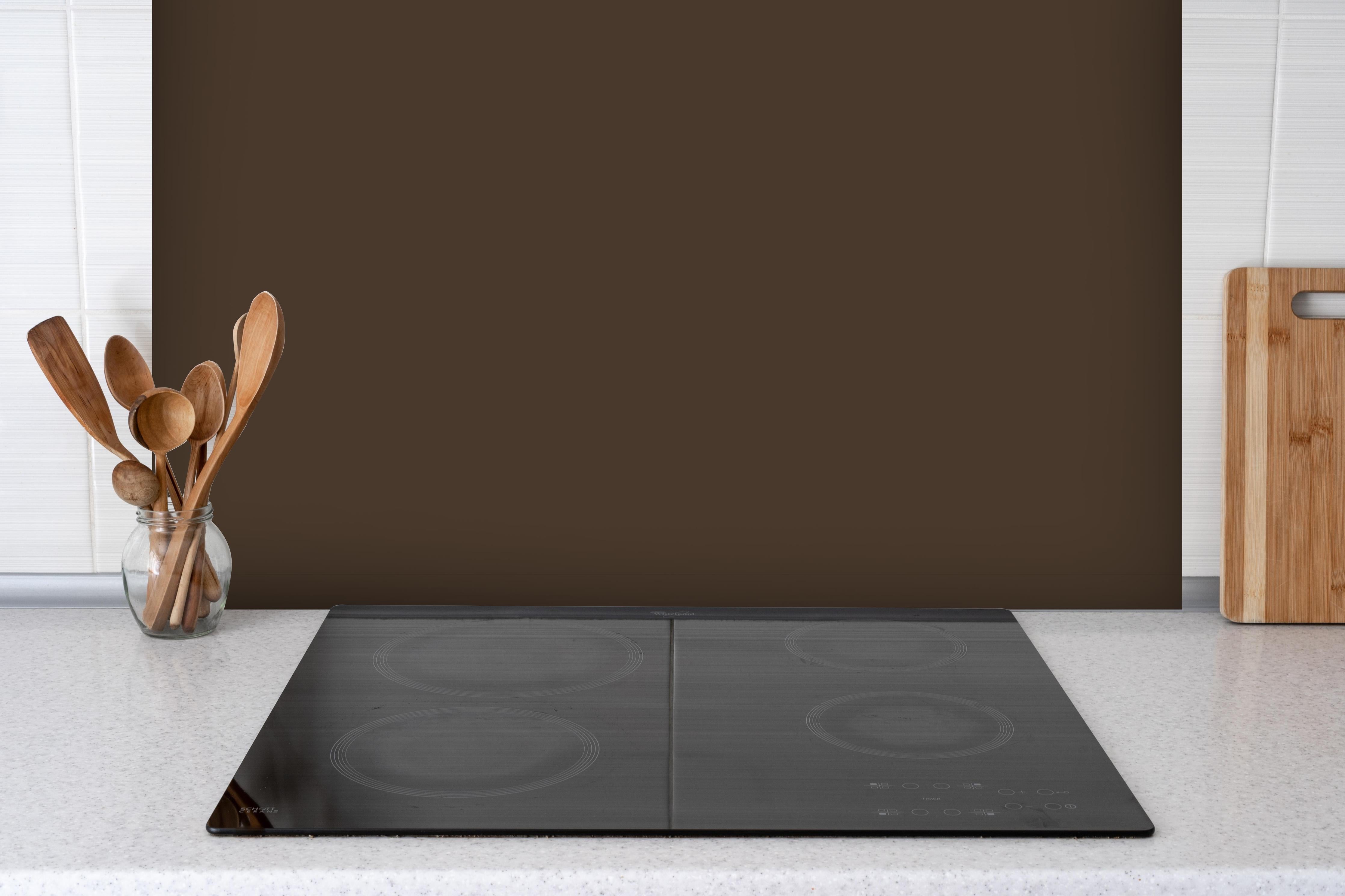 Spritzschutz - RAL 8014 (Sepiabraun) hinter einem Cerankochfeld zwischen Holz-Kochutensilien