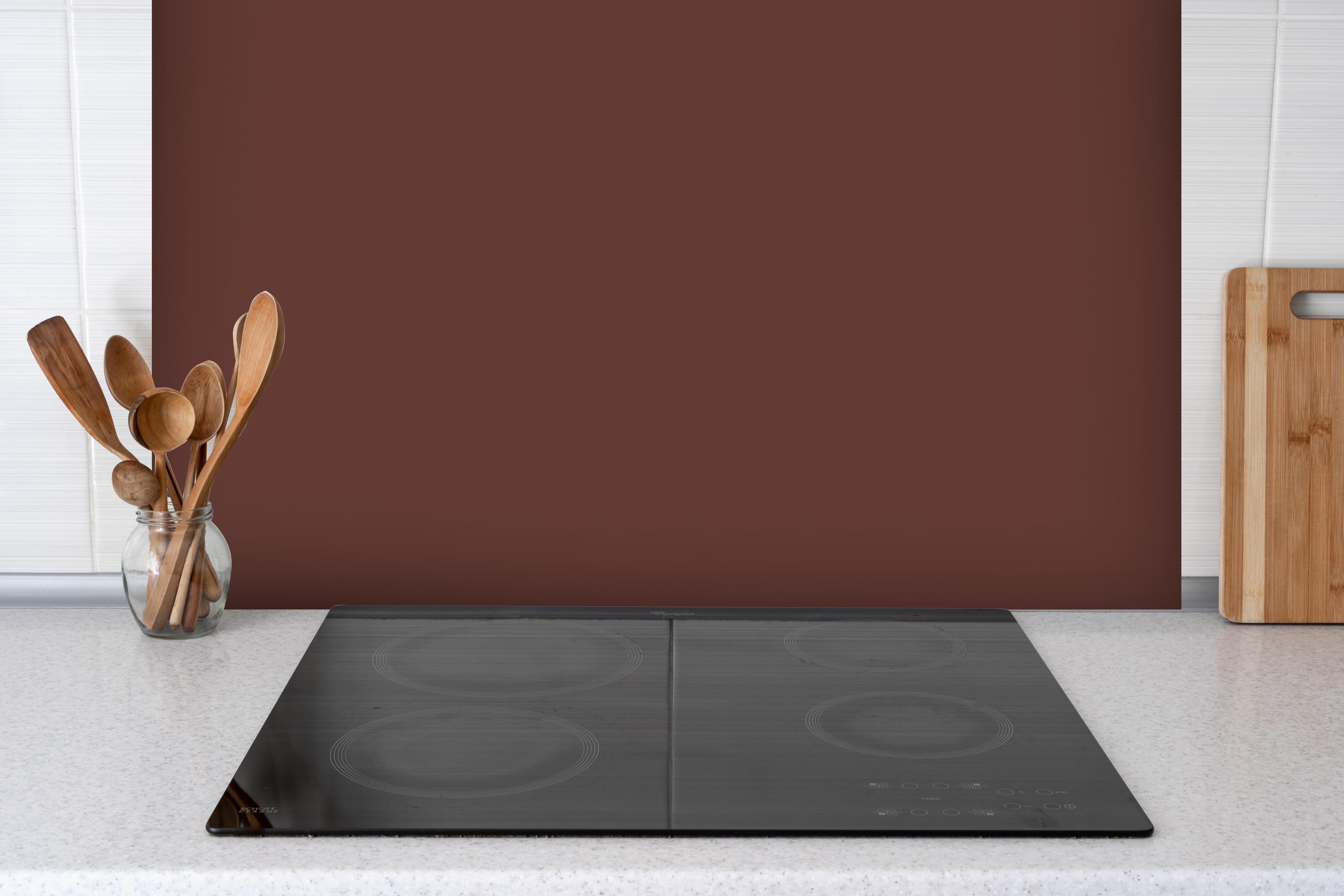 Spritzschutz - RAL 8015 (Kastanienbraun) hinter einem Cerankochfeld zwischen Holz-Kochutensilien