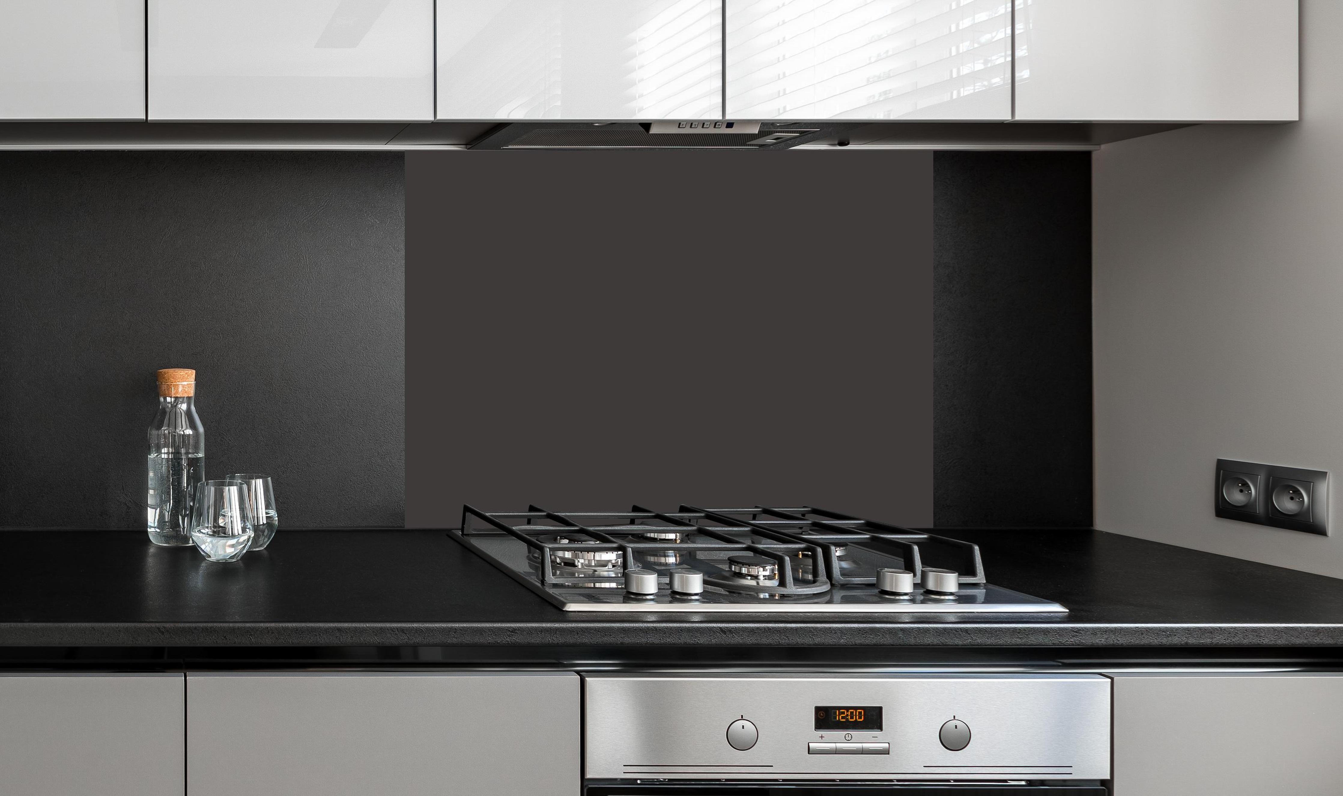 Spritzschutz - RAL 8019 (Graubraun) an edler Anthrazit-Wand hinter silbernem Gasherd