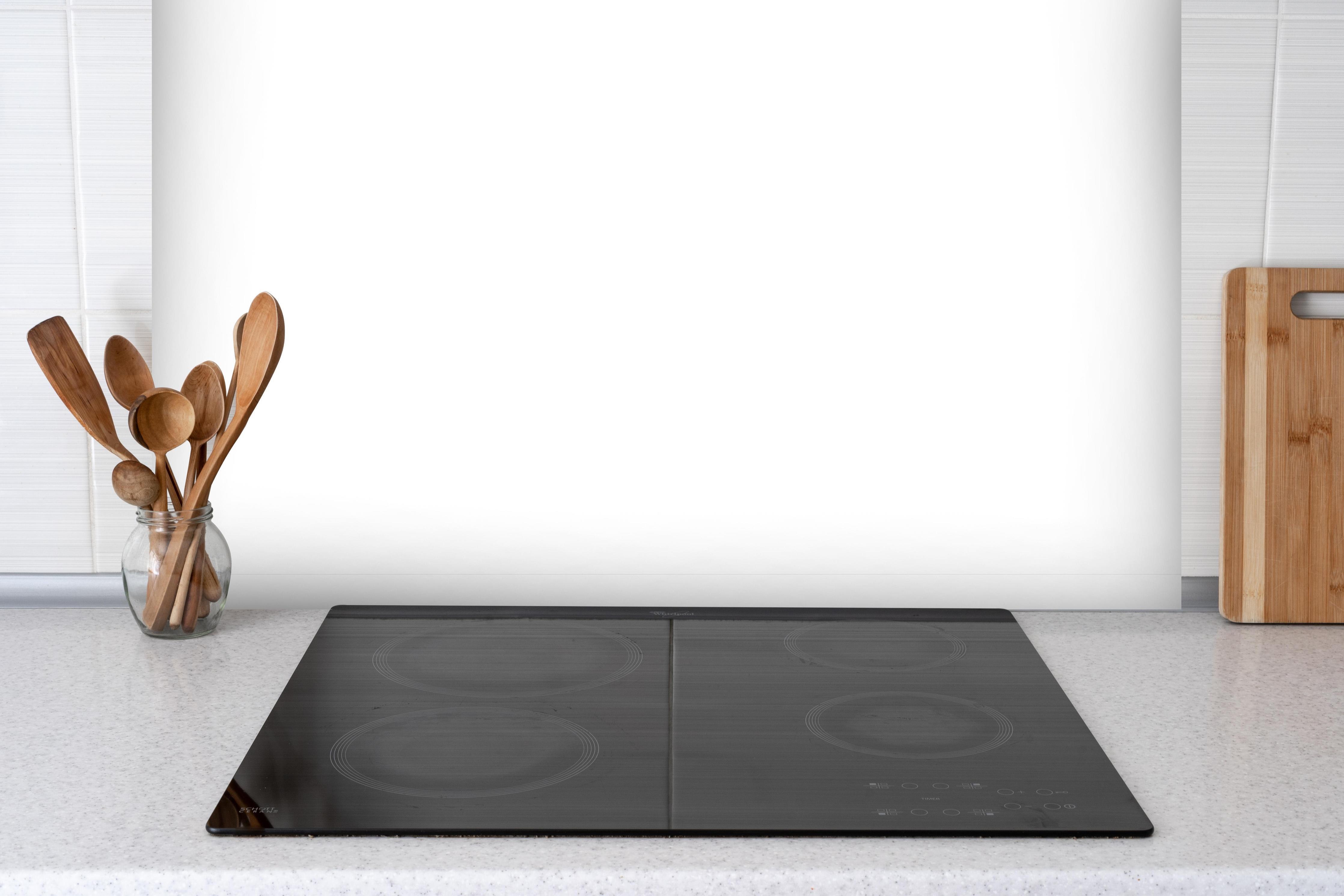 Spritzschutz - RAL Farbe Weiß hinter einem Cerankochfeld zwischen Holz-Kochutensilien