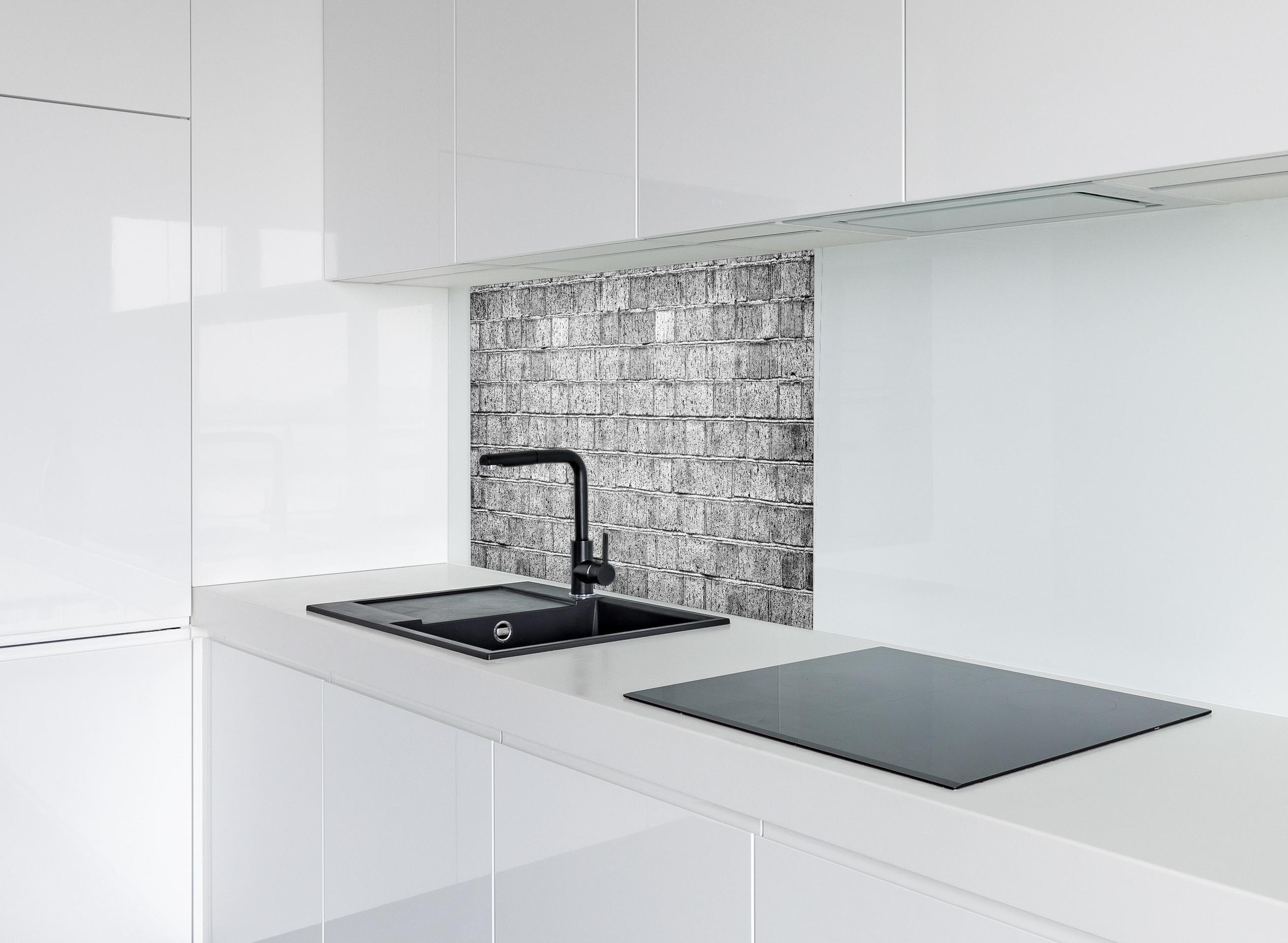 Spritzschutz - Raues hellgraues Mauerwerk hinter modernem schwarz-matten Spülbecken in weißer Hochglanz-Küche
