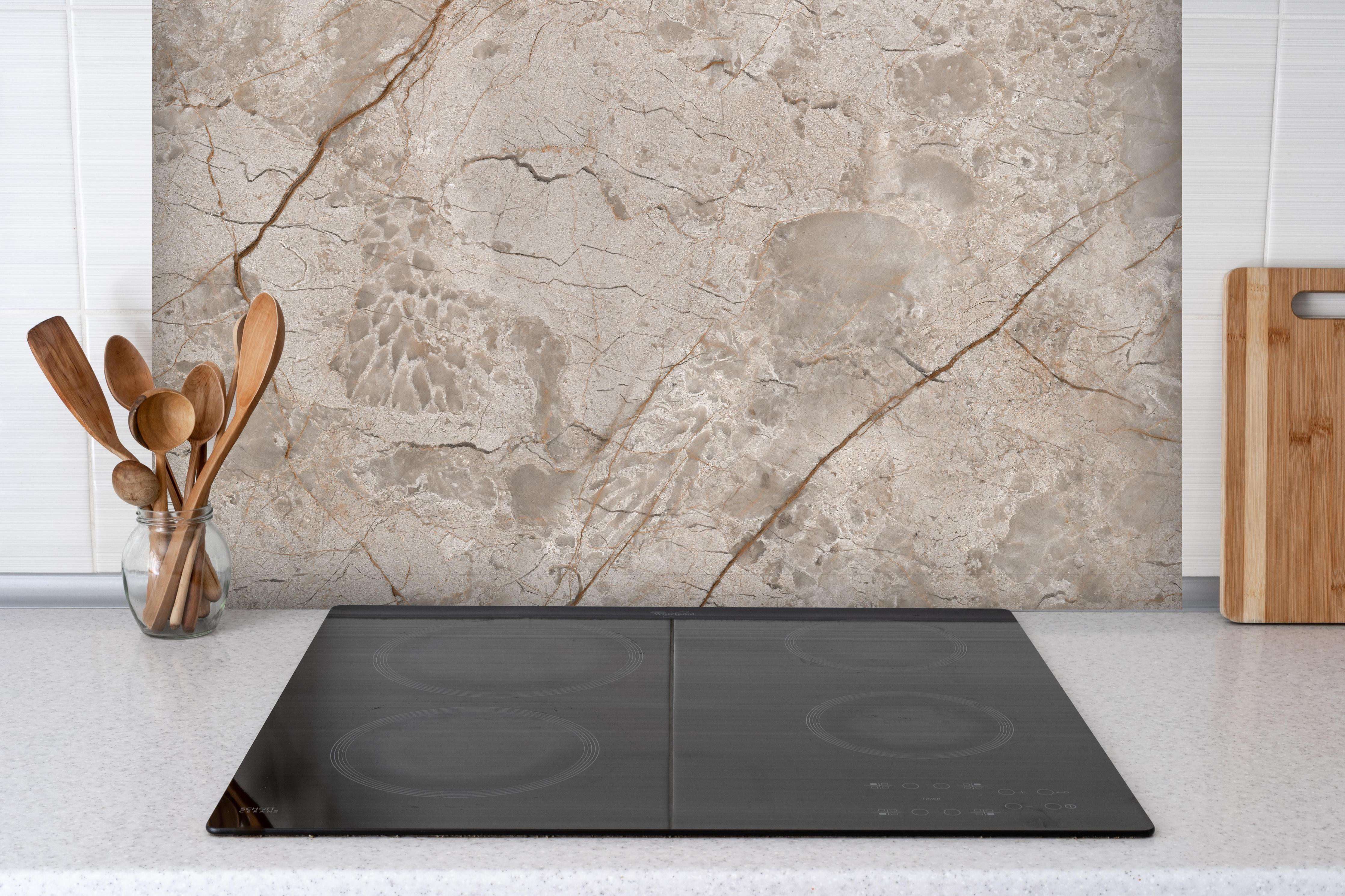 Spritzschutz - Rissiger beiger Marmor hinter einem Cerankochfeld zwischen Holz-Kochutensilien