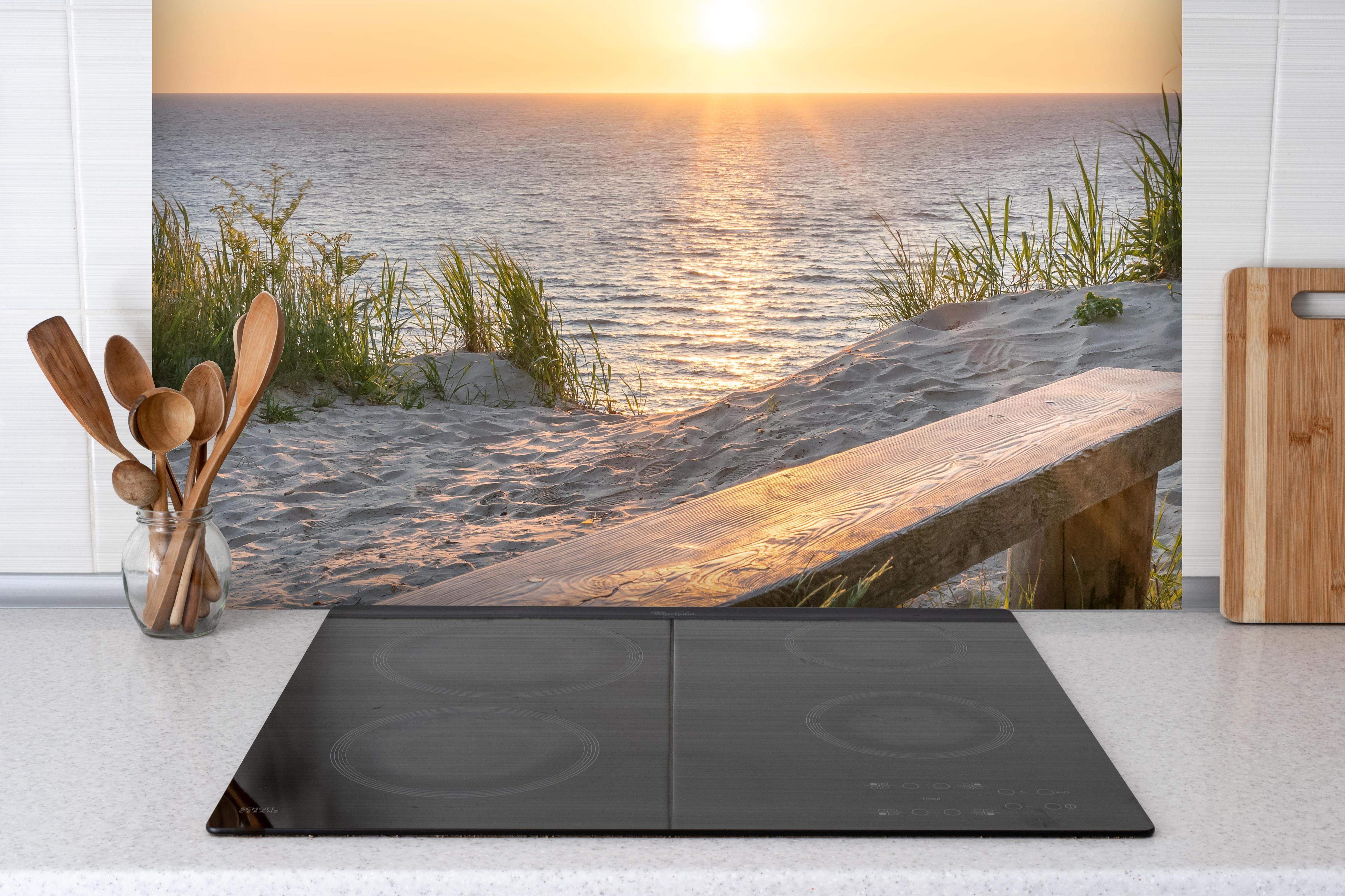 Spritzschutz - Ruhiger Sonnenuntergang - Ostsee hinter einem Cerankochfeld zwischen Holz-Kochutensilien