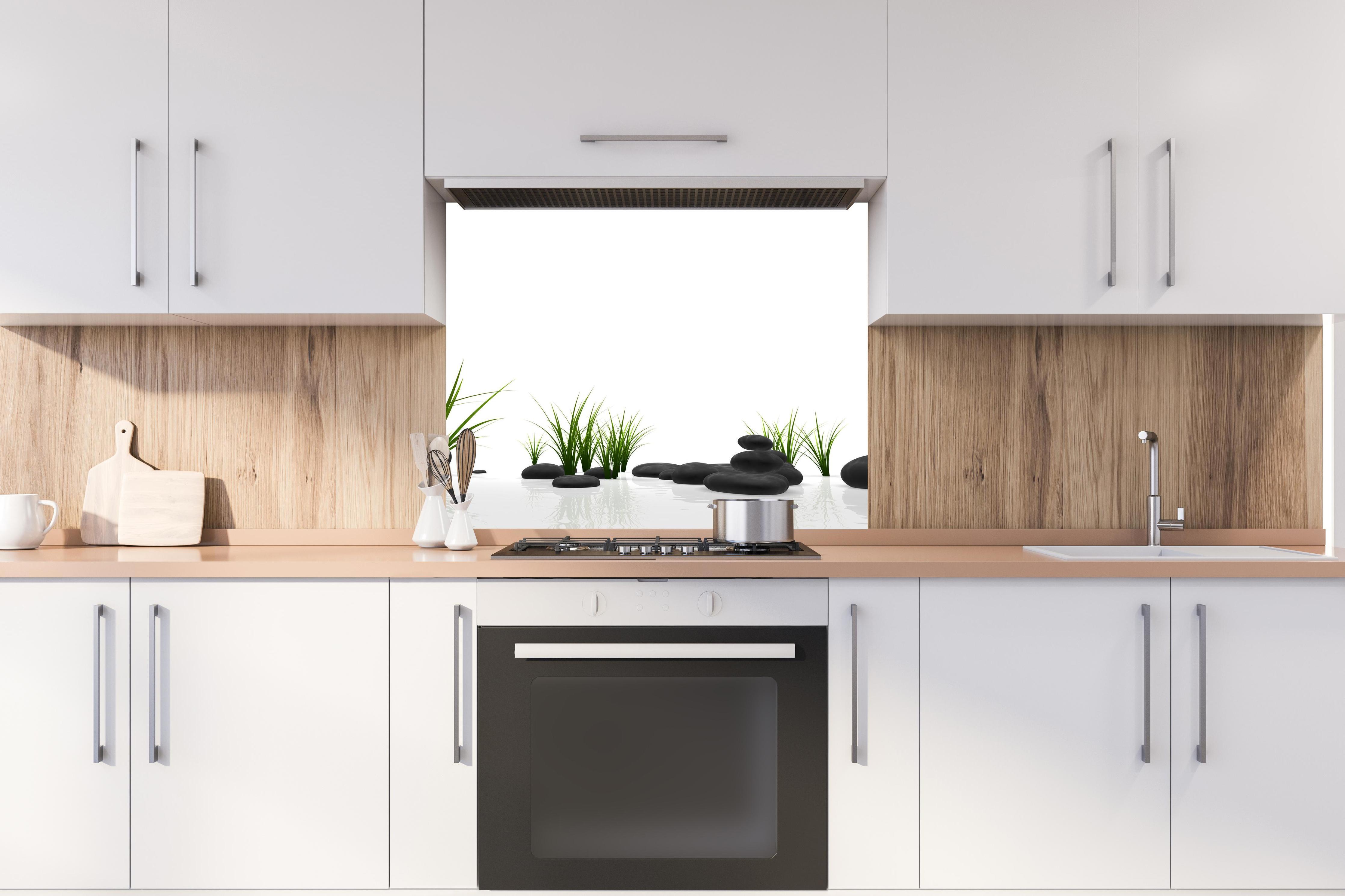 Spritzschutz - Ruhiges Steine Gefilde mit Gras und Wasser hinter stilvollem Gasherd unter Dunstabzugshaube