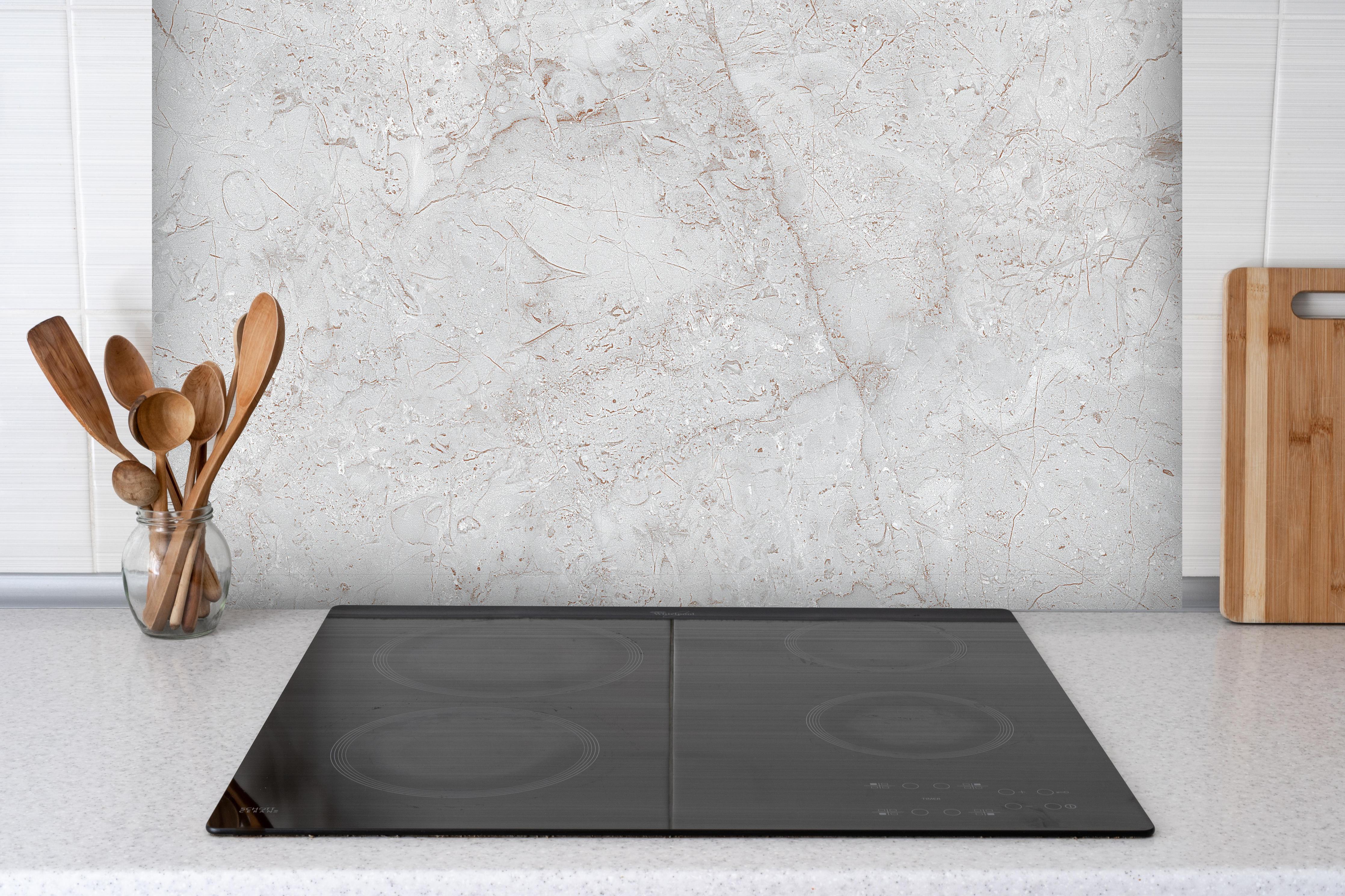 Spritzschutz - Rustikales Marmor-Design hinter einem Cerankochfeld zwischen Holz-Kochutensilien