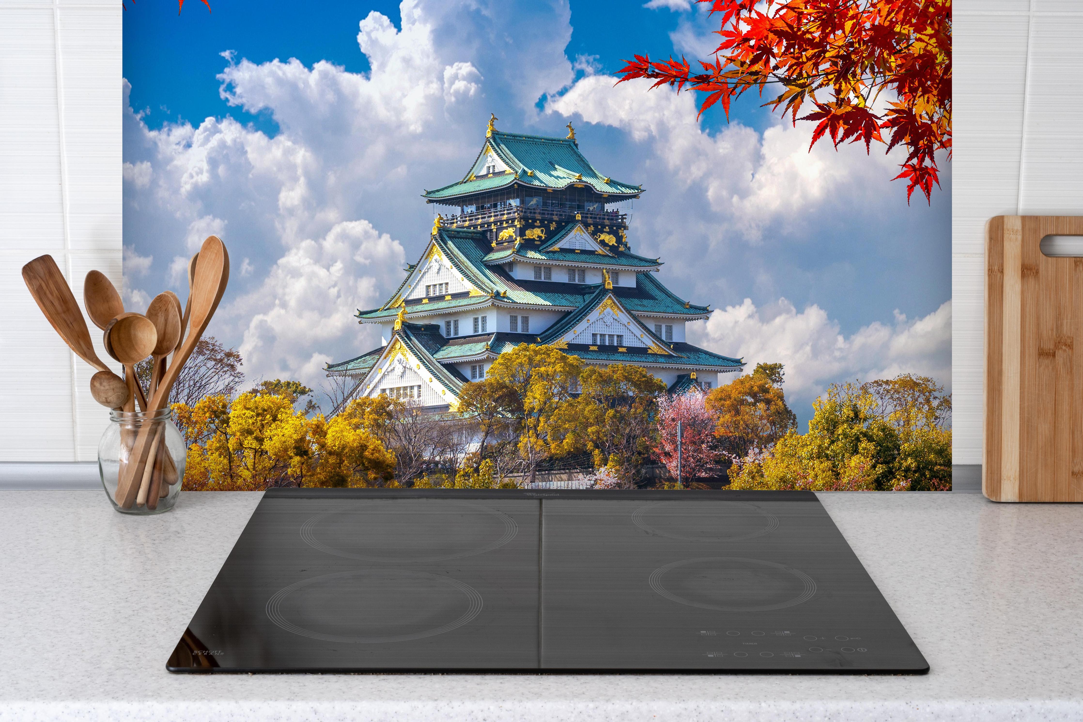 Spritzschutz - Schloss Osaka im Herbst hinter einem Cerankochfeld zwischen Holz-Kochutensilien