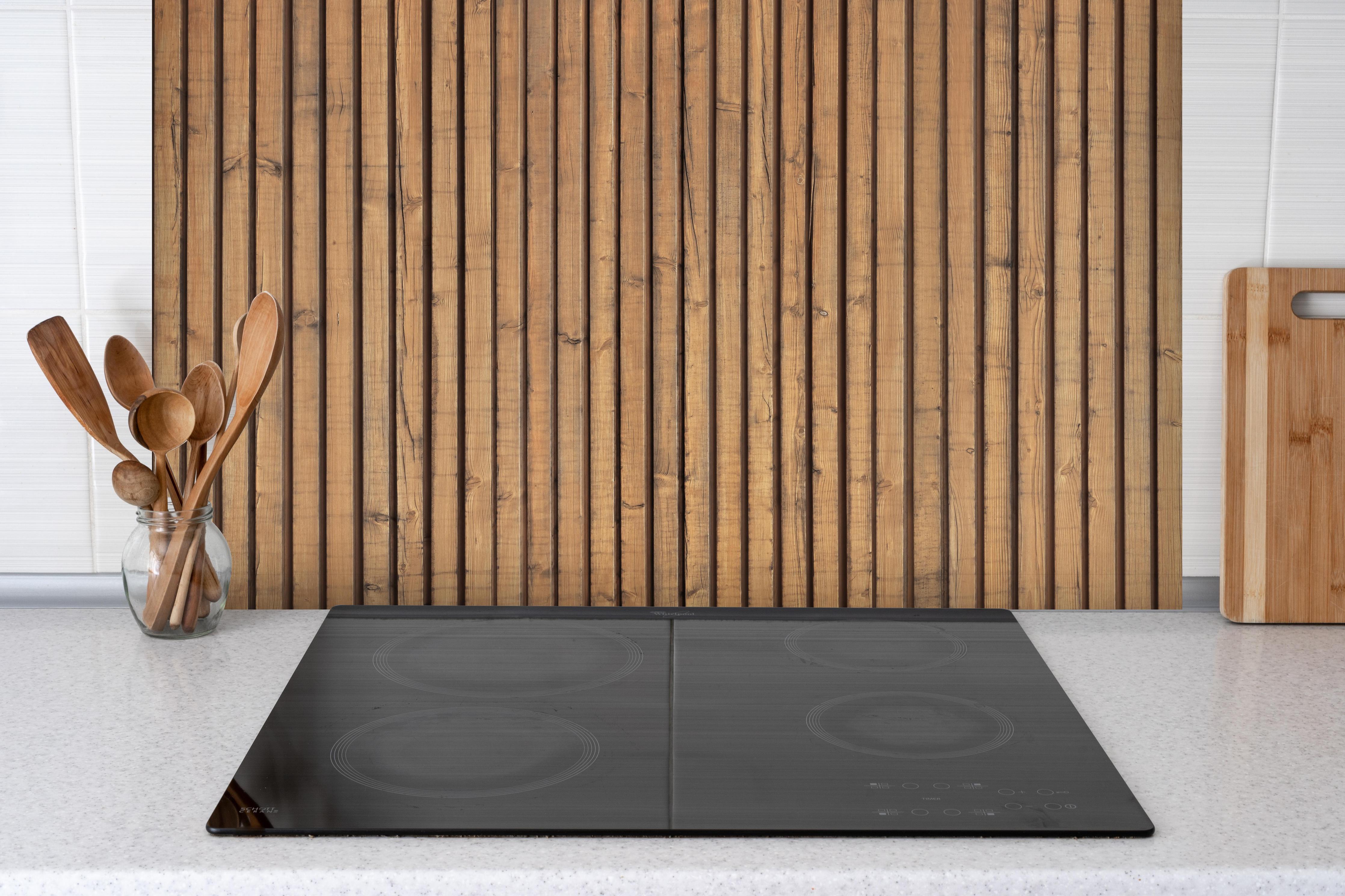 Spritzschutz - Schöne Holzwand hinter einem Cerankochfeld zwischen Holz-Kochutensilien