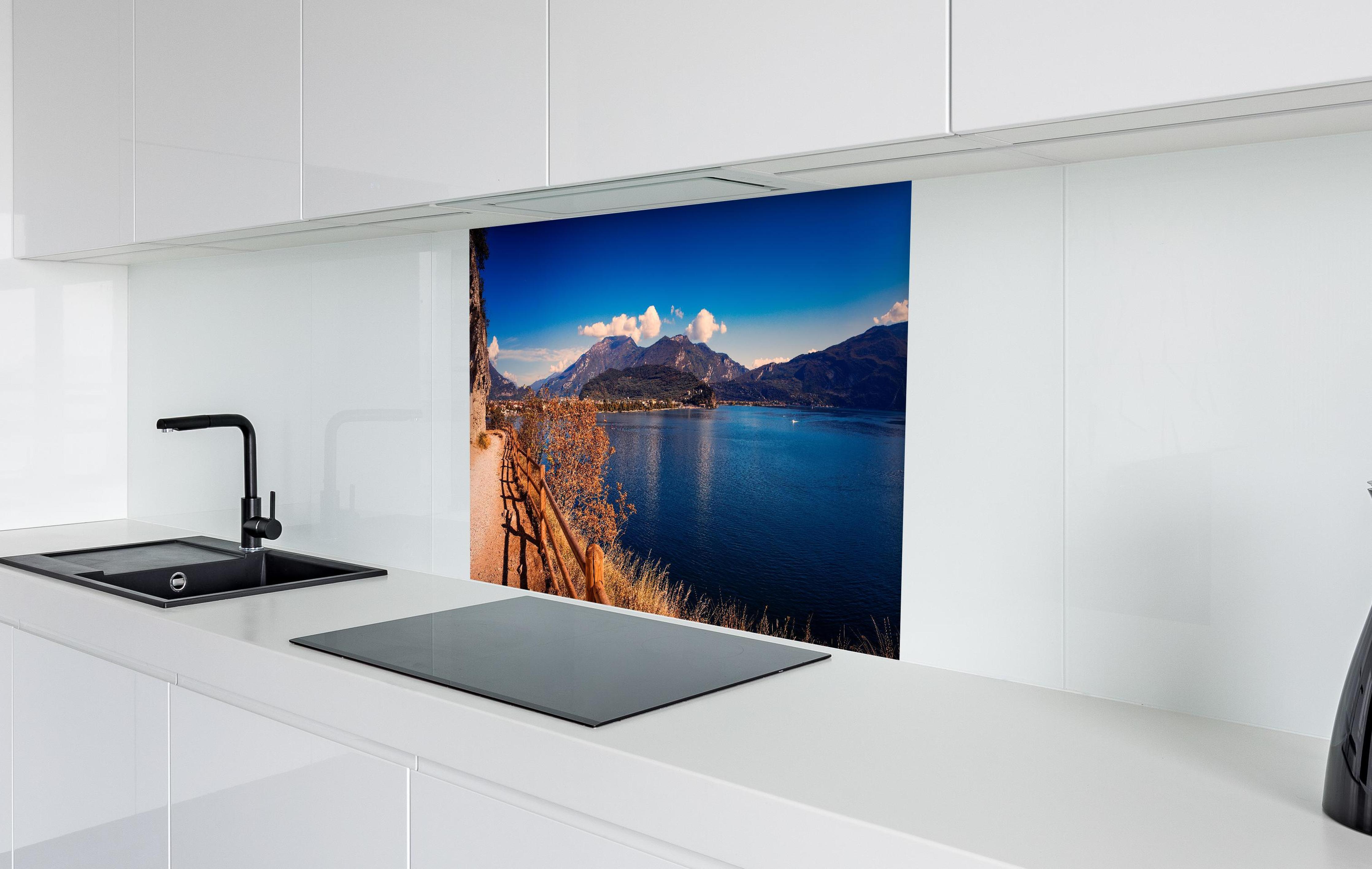 Spritzschutz - Schöne Landschaft mit Blick auf den Gardasee in weißer Hochglanz-Küche hinter einem Cerankochfeld