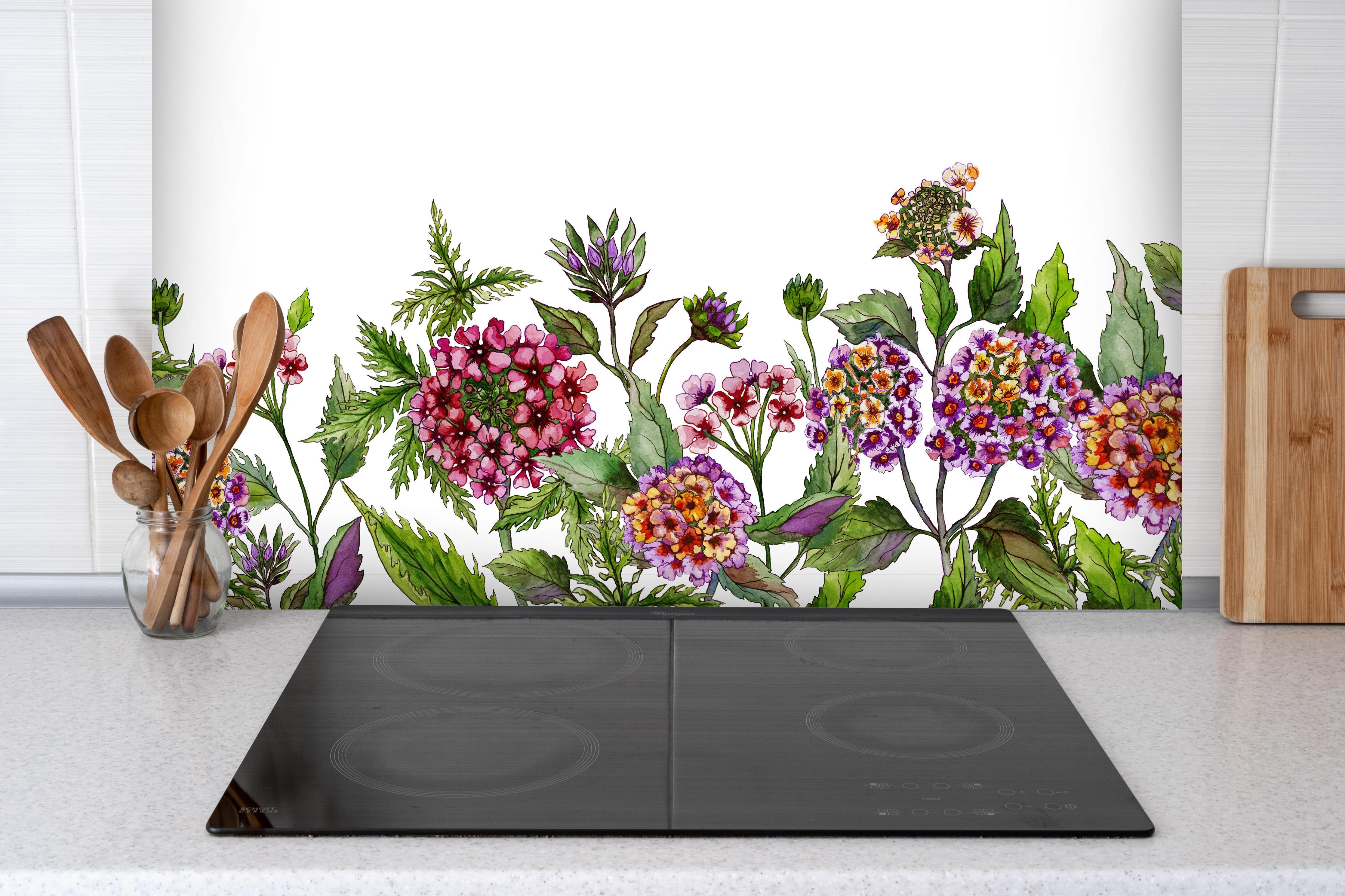 Spritzschutz - Schöne Lantana-Blüten mit grünem Blätter hinter einem Cerankochfeld zwischen Holz-Kochutensilien