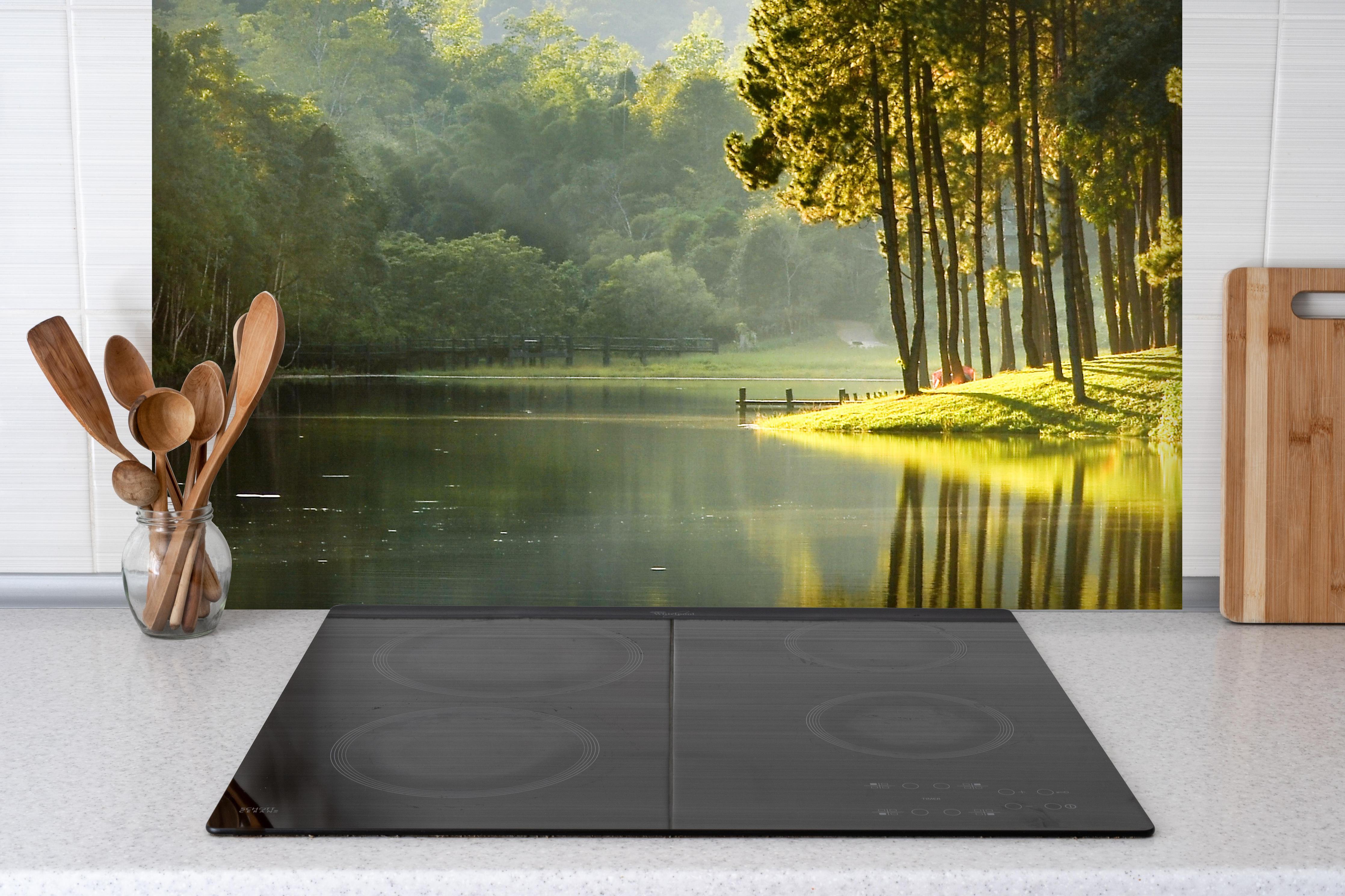 Spritzschutz - Schöne Seelandschaft mit Kiefernwald hinter einem Cerankochfeld zwischen Holz-Kochutensilien