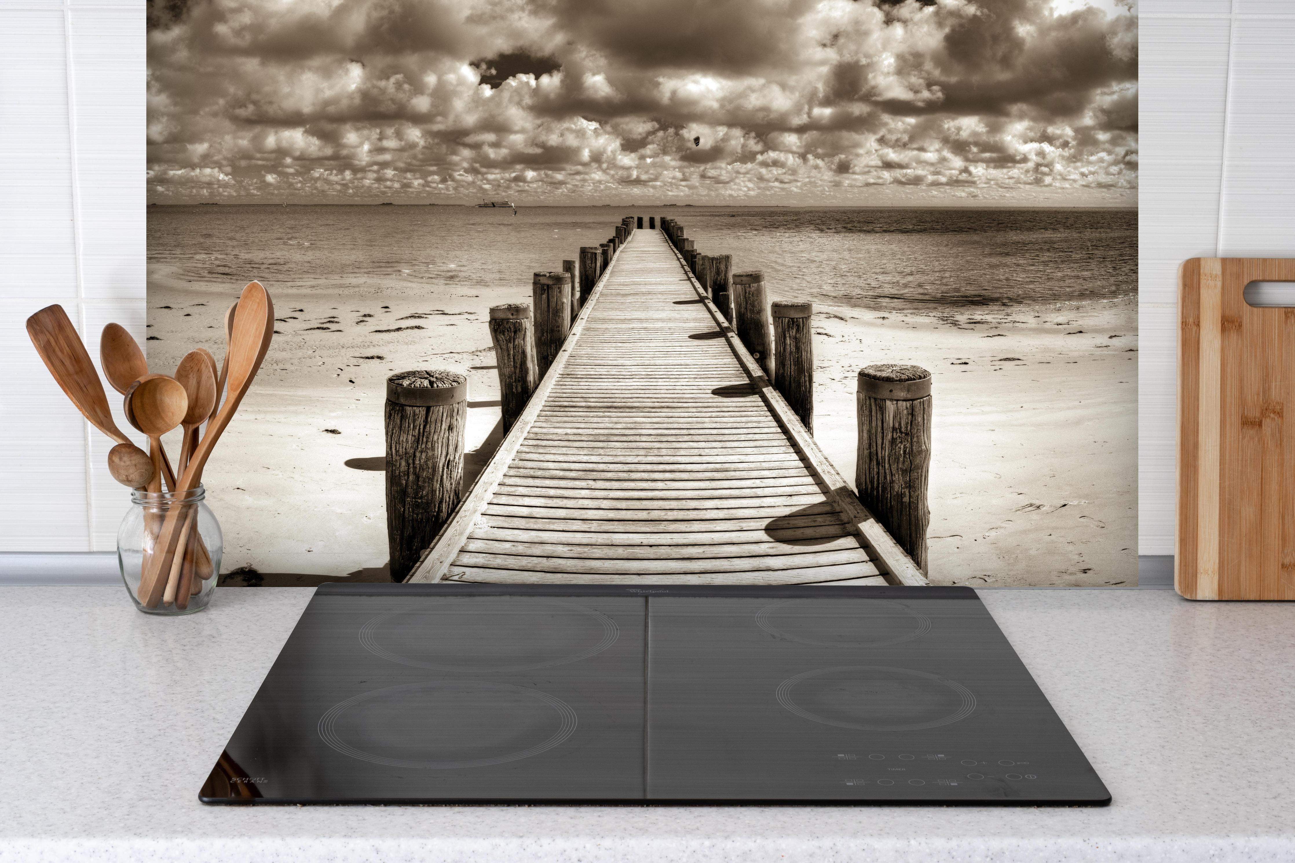 Spritzschutz - Schöner Anlegersteg für Boote hinter einem Cerankochfeld zwischen Holz-Kochutensilien