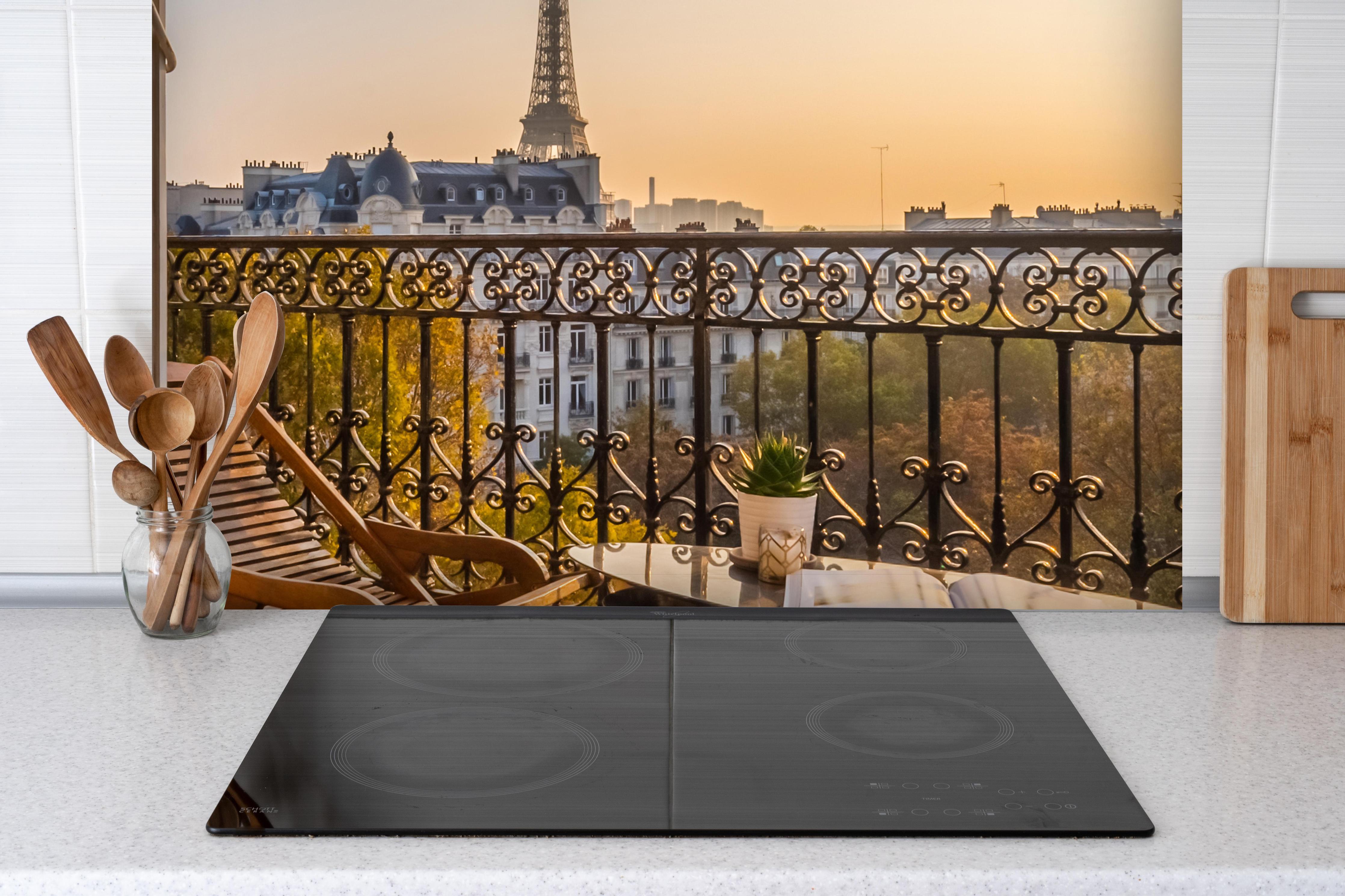 Spritzschutz - Schöner Pariser Balkon bei Sonnenuntergang hinter einem Cerankochfeld zwischen Holz-Kochutensilien