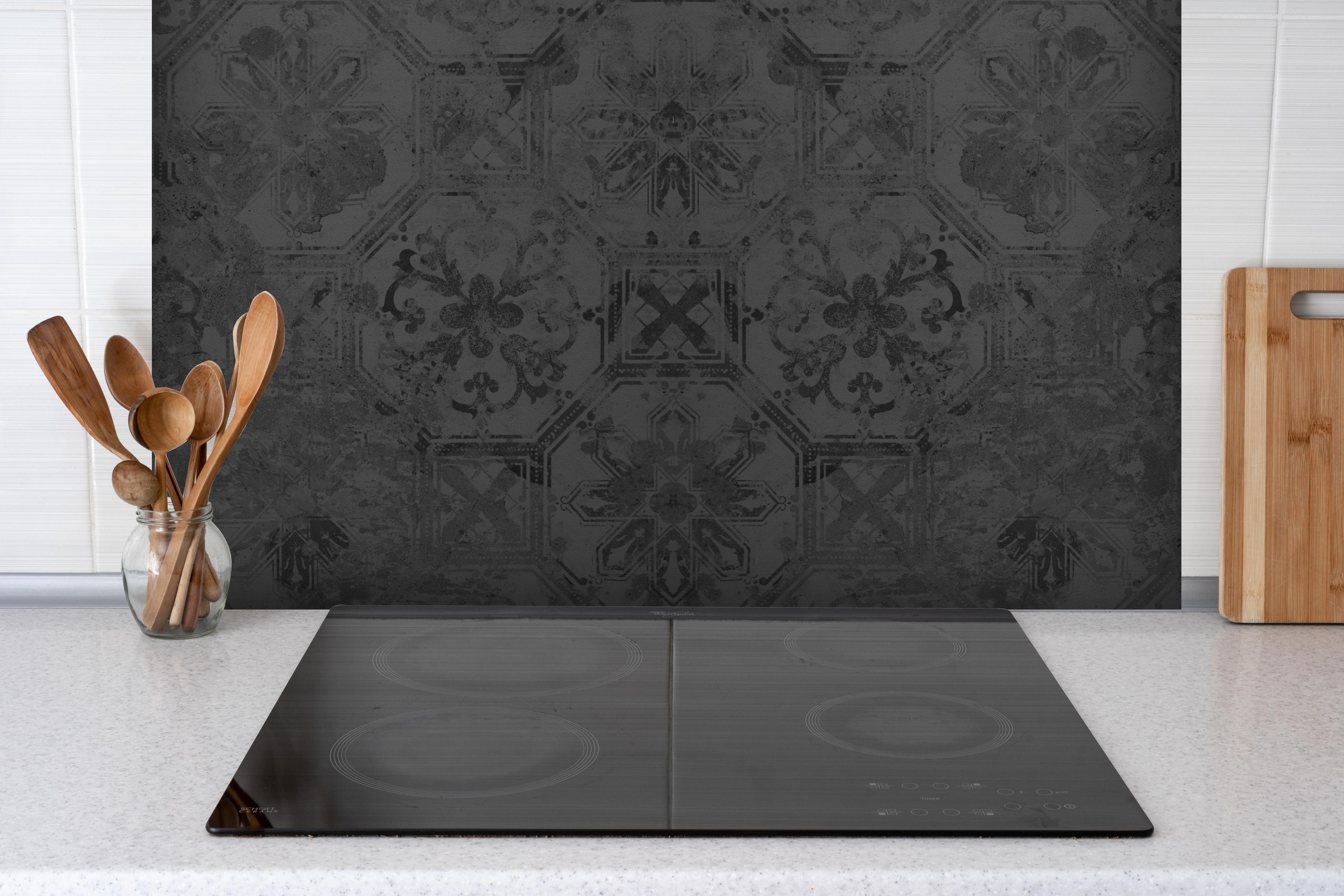 Spritzschutz - Schwarze Keramik Motiv hinter einem Cerankochfeld zwischen Holz-Kochutensilien