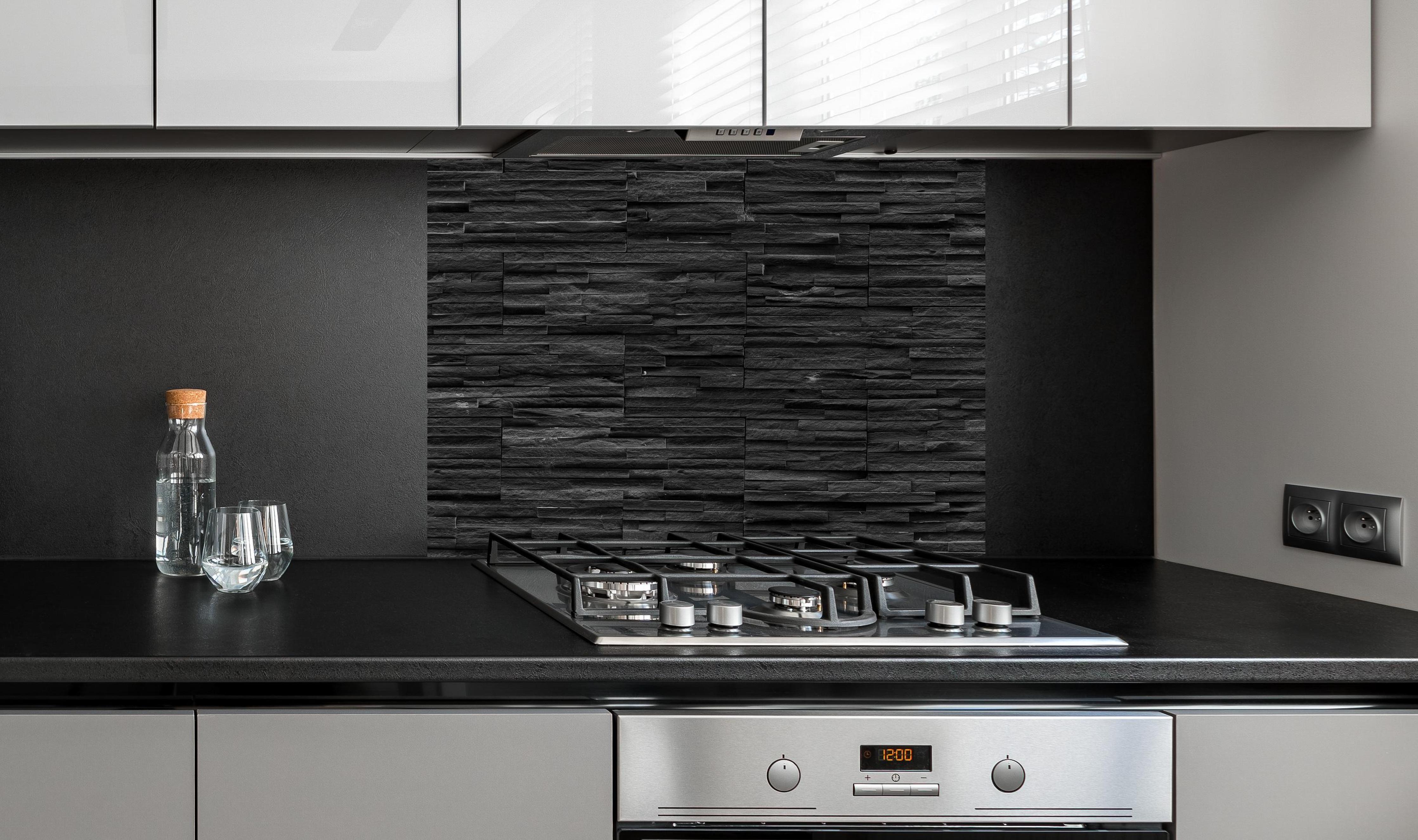 Spritzschutz - Schwarze Schieferstein-Mauer an edler Anthrazit-Wand hinter silbernem Gasherd