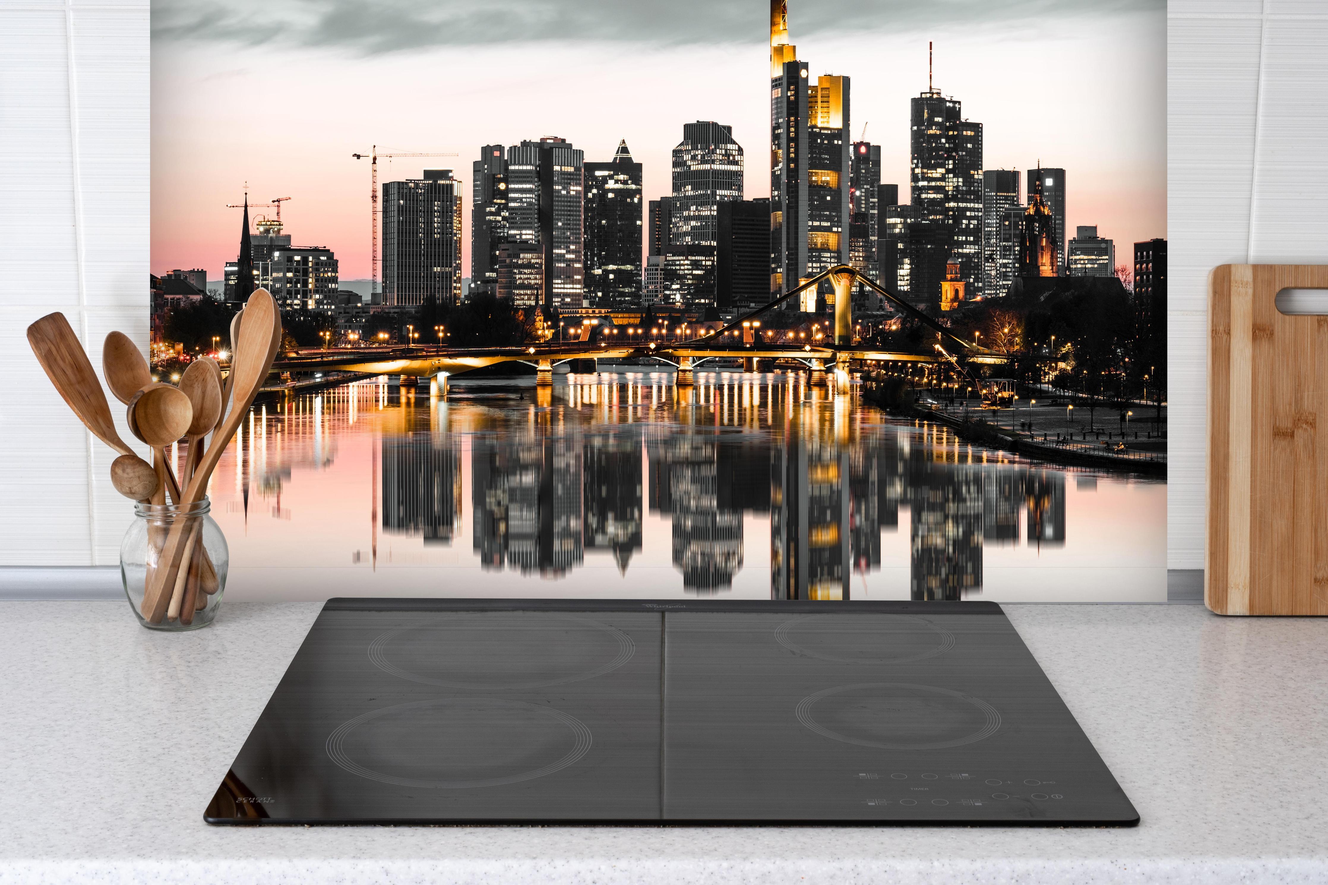 Spritzschutz - Skyline Frankfurt mit Wasser Spiegelung hinter einem Cerankochfeld zwischen Holz-Kochutensilien