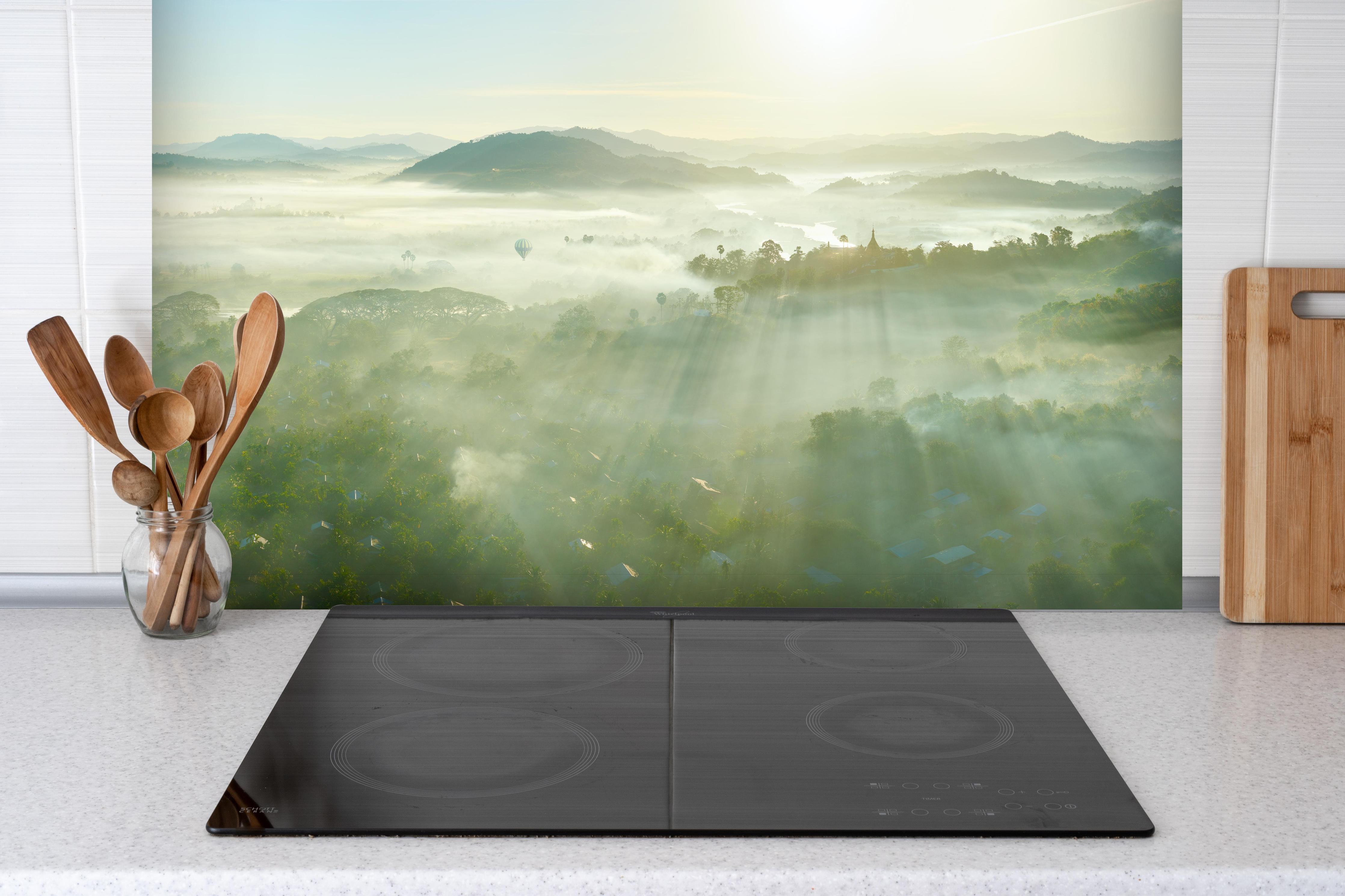 Spritzschutz - Sonnenaufgang in den Bergen Myanmars hinter einem Cerankochfeld zwischen Holz-Kochutensilien