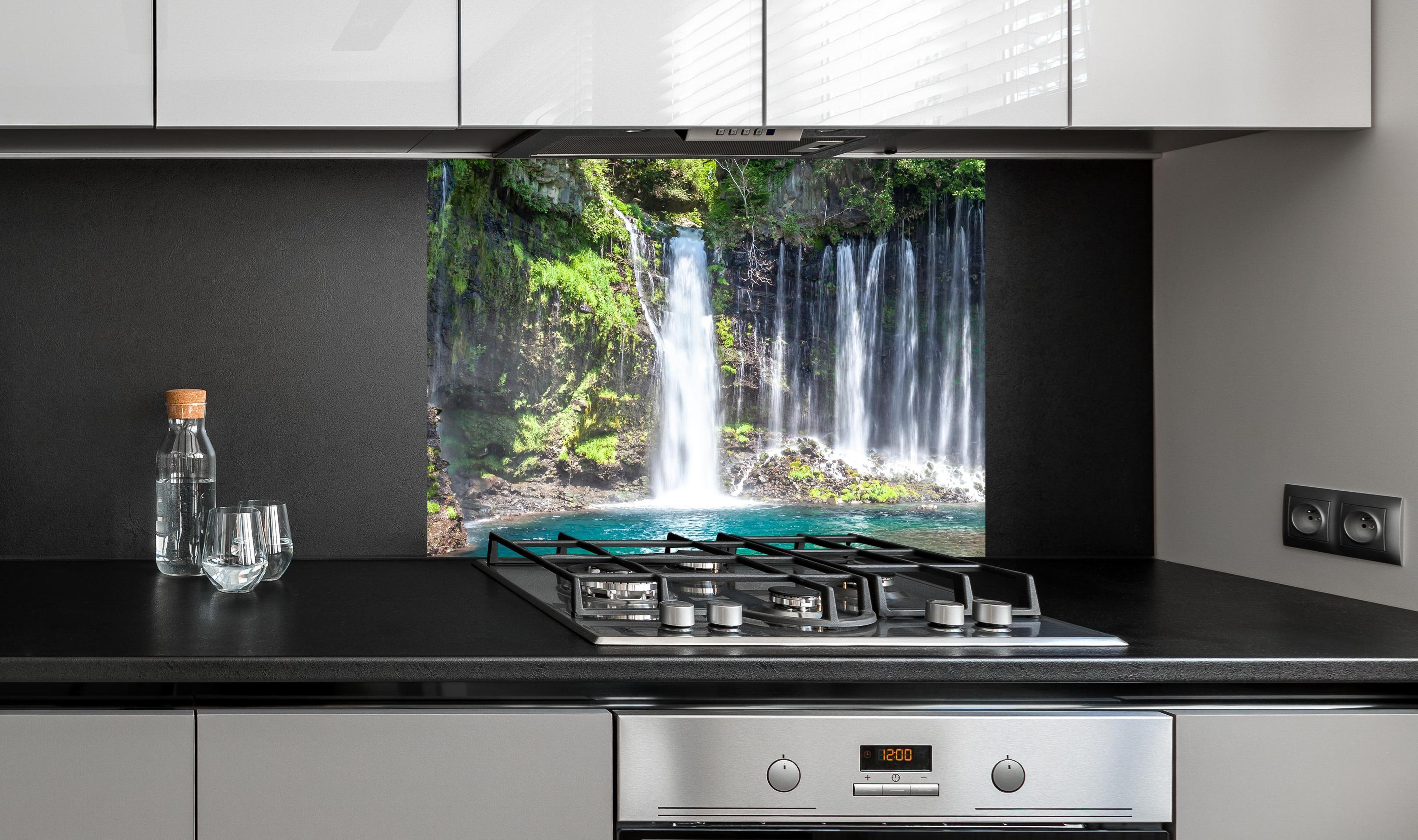 Spritzschutz - Sonniger Shiraito-Wasserfall an edler Anthrazit-Wand hinter silbernem Gasherd