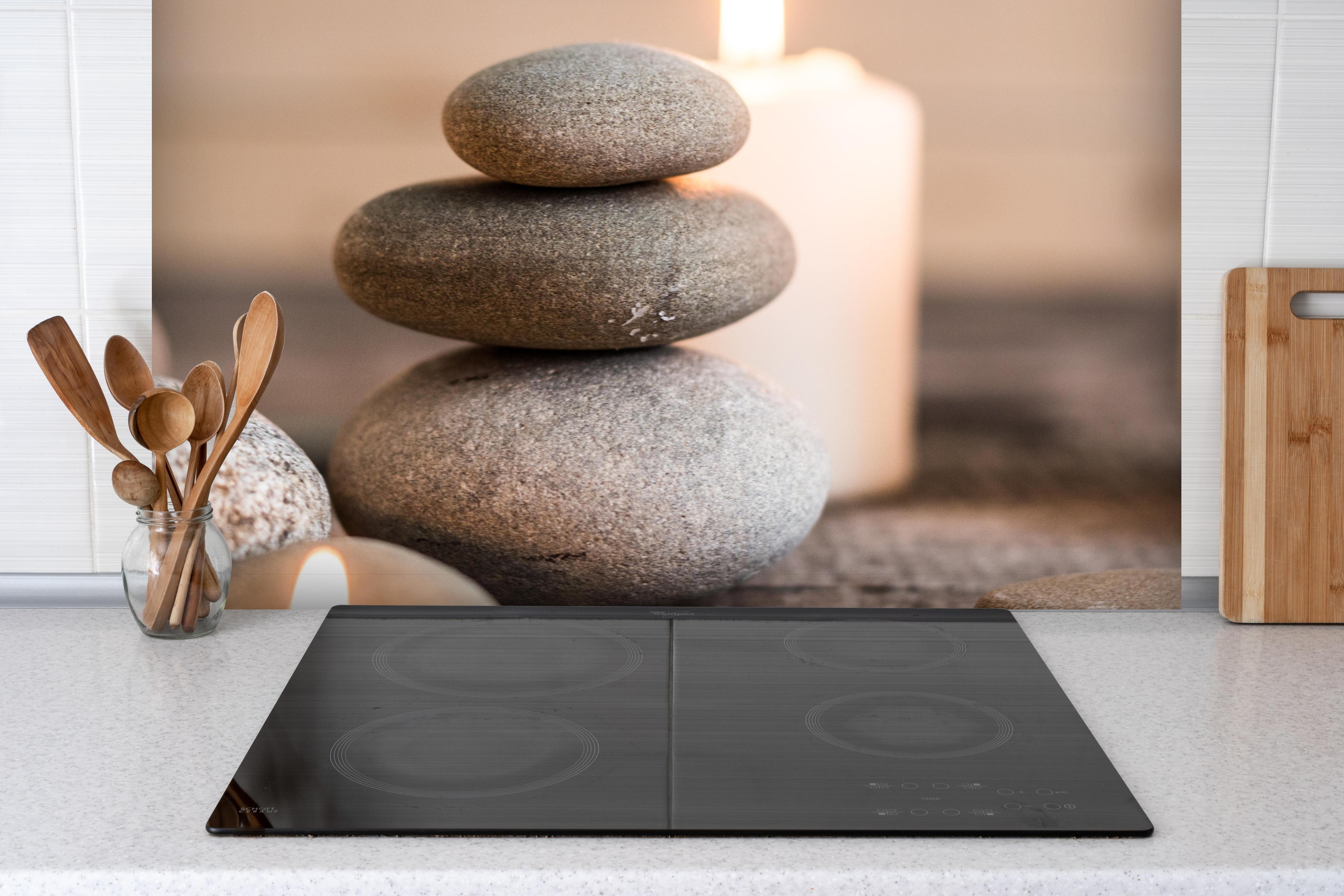 Spritzschutz - Spa-Stillleben mit Kerzen hinter einem Cerankochfeld zwischen Holz-Kochutensilien