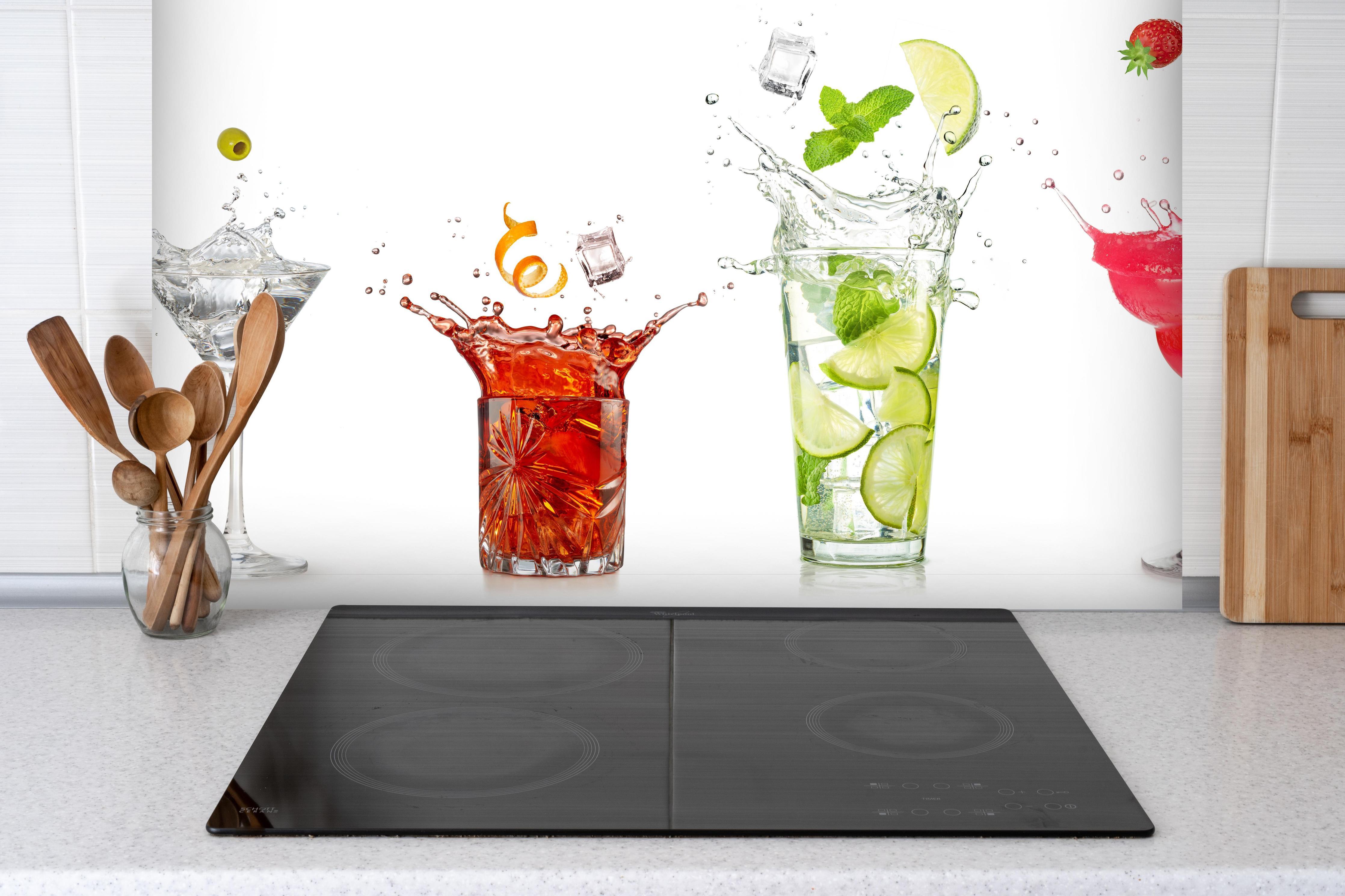 Spritzschutz - Spritzende Cocktails hinter einem Cerankochfeld zwischen Holz-Kochutensilien