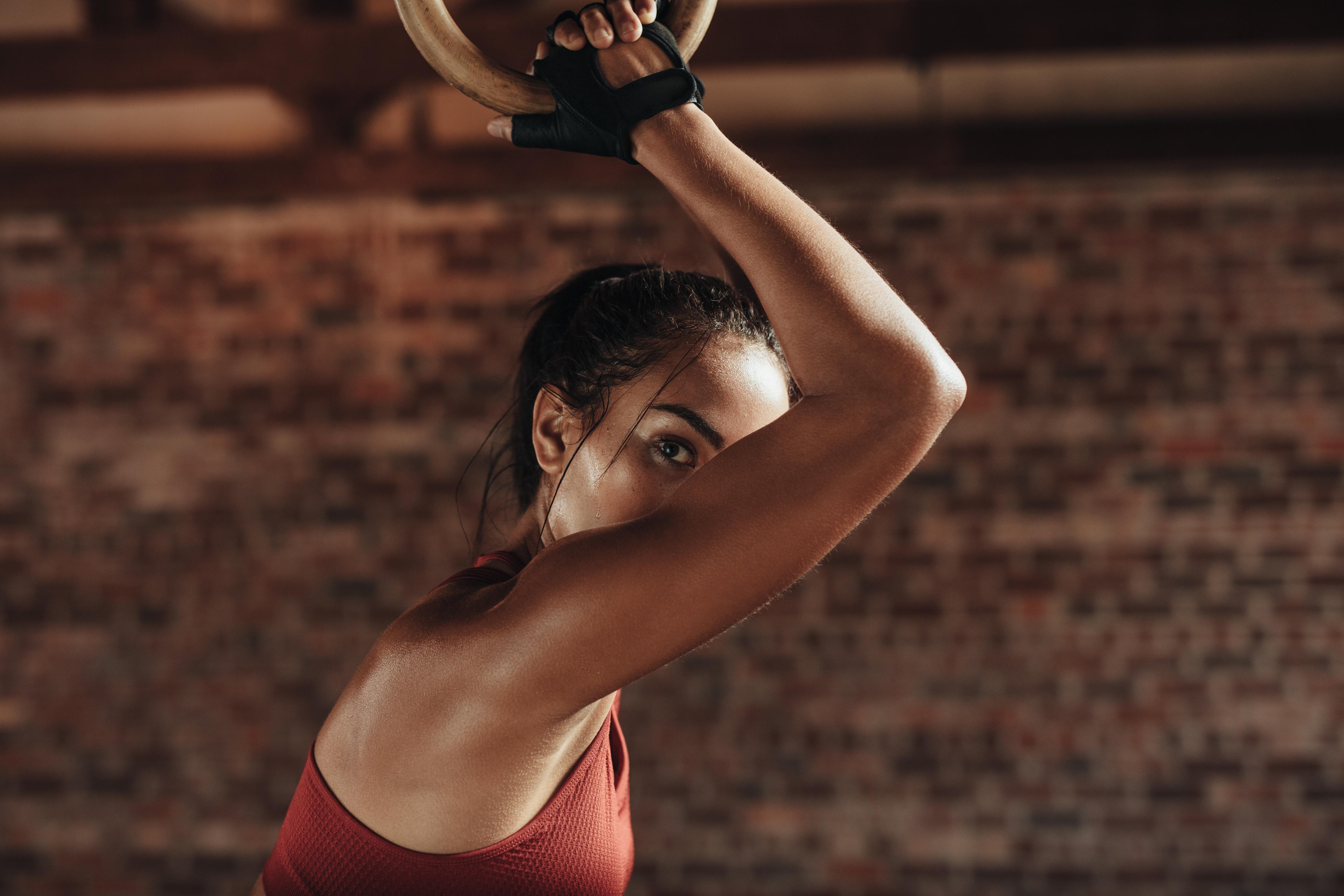 Spritzschutz-Starke Frau beim Training mit Dip-Ringen