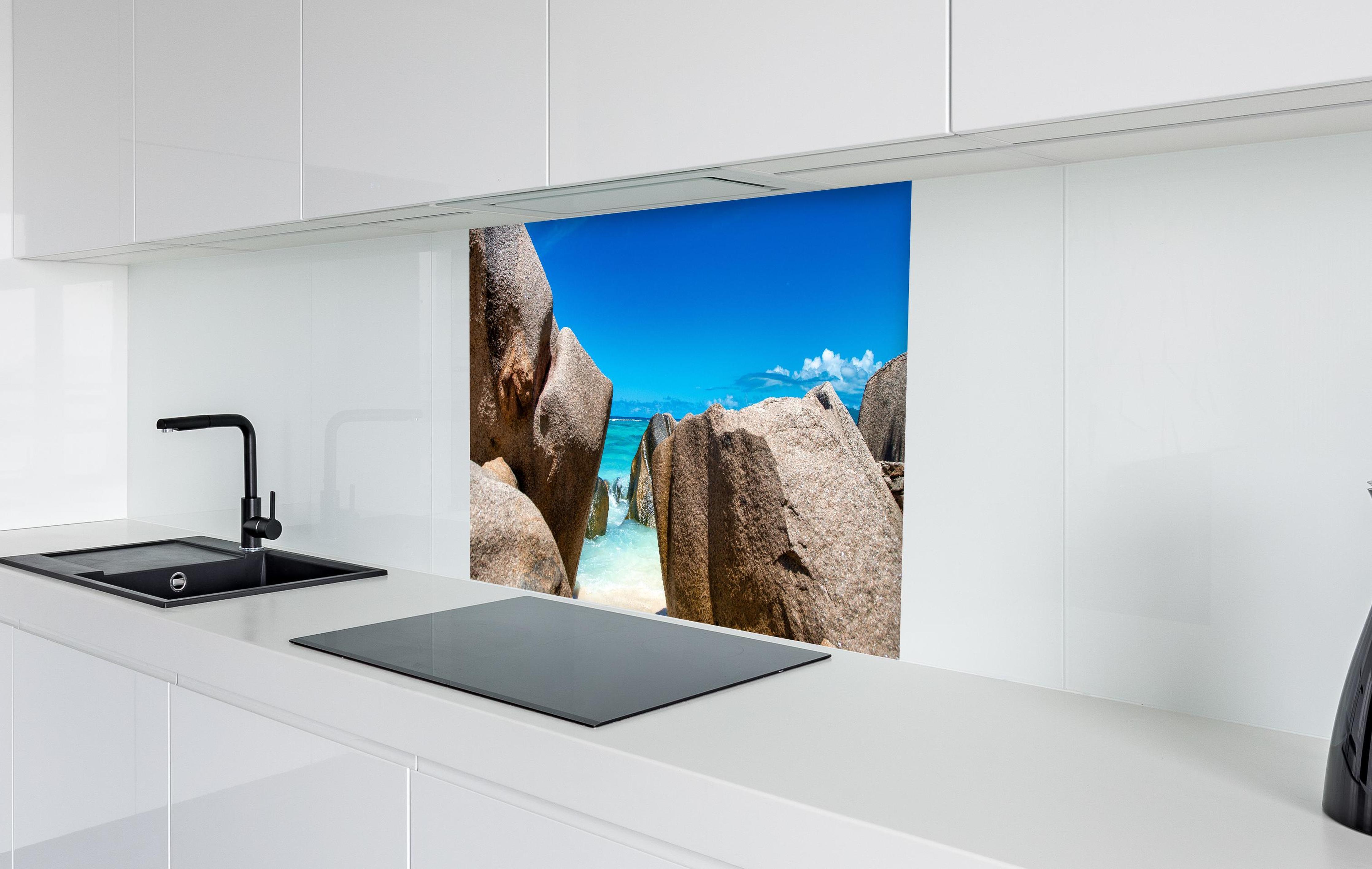 Spritzschutz - Stein-Panorama auf den Seychellen in weißer Hochglanz-Küche hinter einem Cerankochfeld