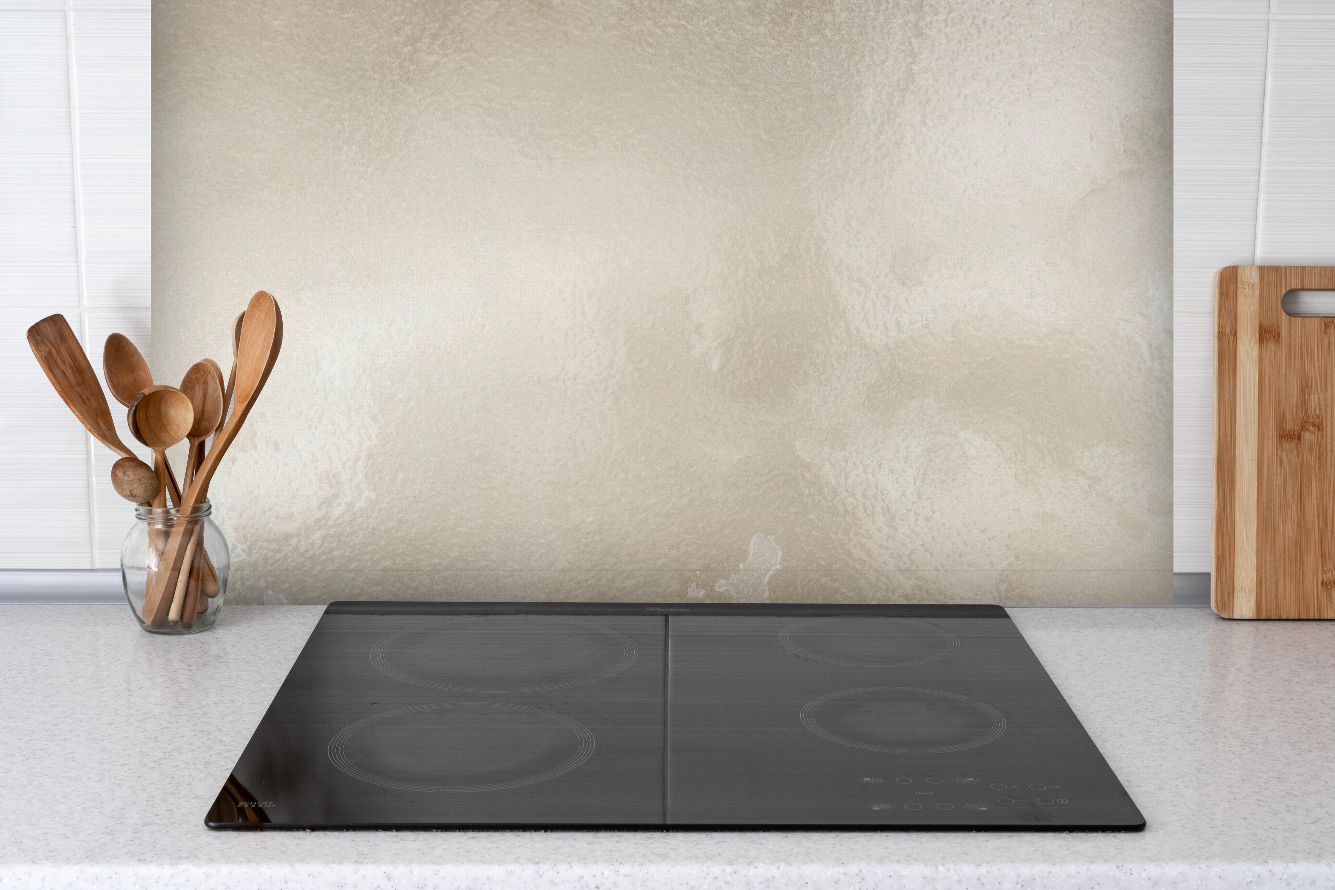 Spritzschutz - Steinartiges Aquarell hinter einem Cerankochfeld zwischen Holz-Kochutensilien