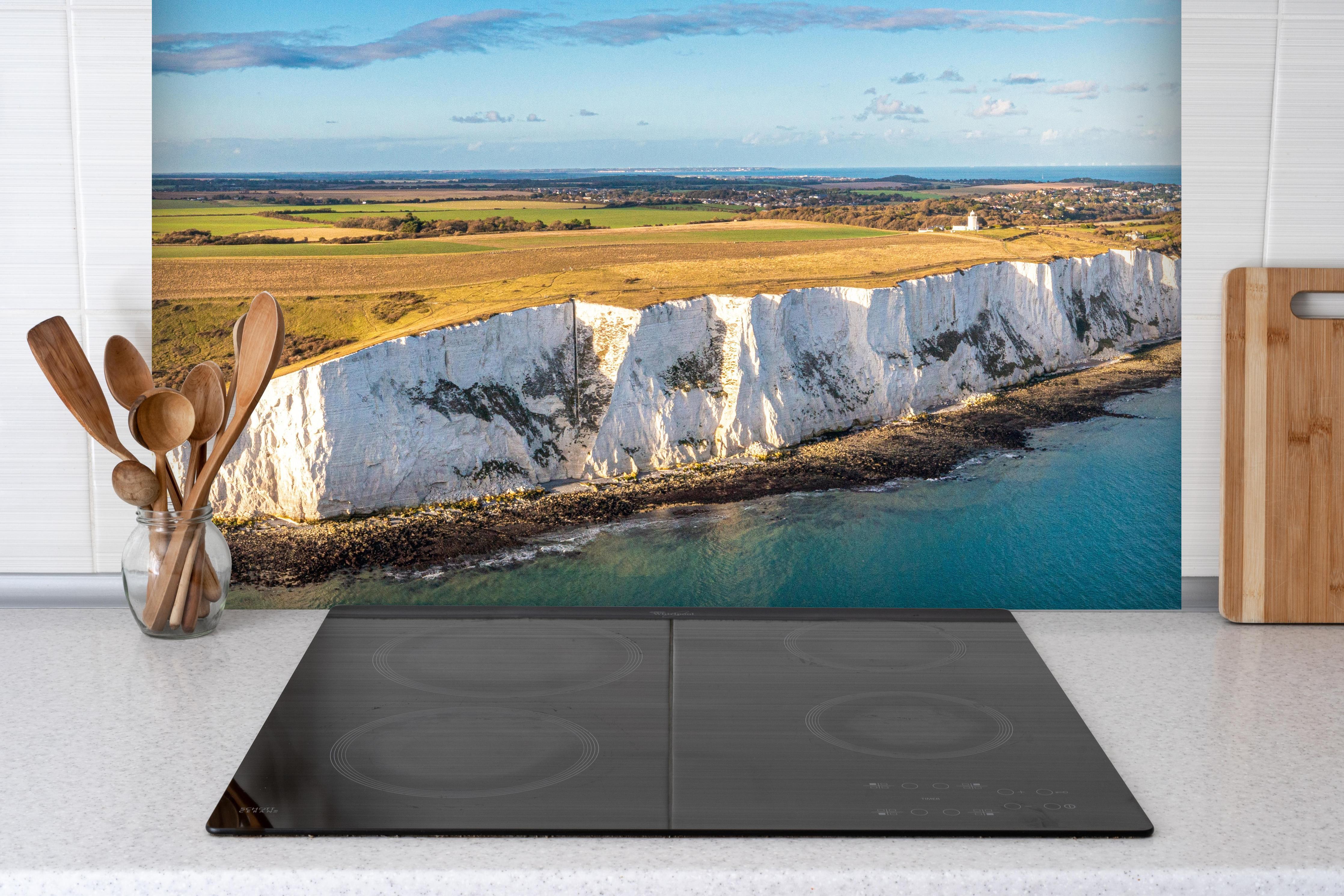 Spritzschutz - Strahlende White Cliffs of Dover hinter einem Cerankochfeld zwischen Holz-Kochutensilien