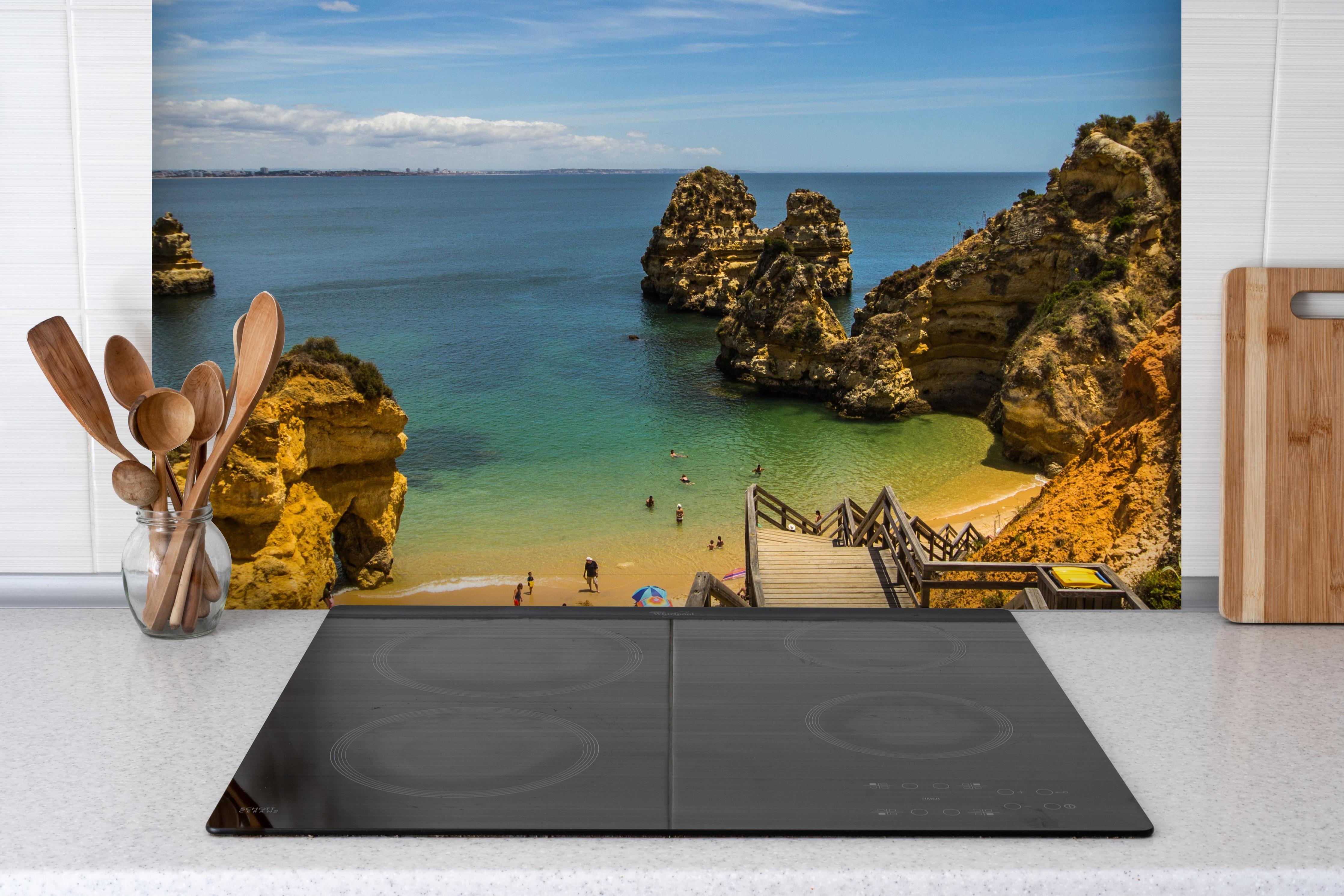 Spritzschutz - Strand Camilo in Lagos hinter einem Cerankochfeld zwischen Holz-Kochutensilien