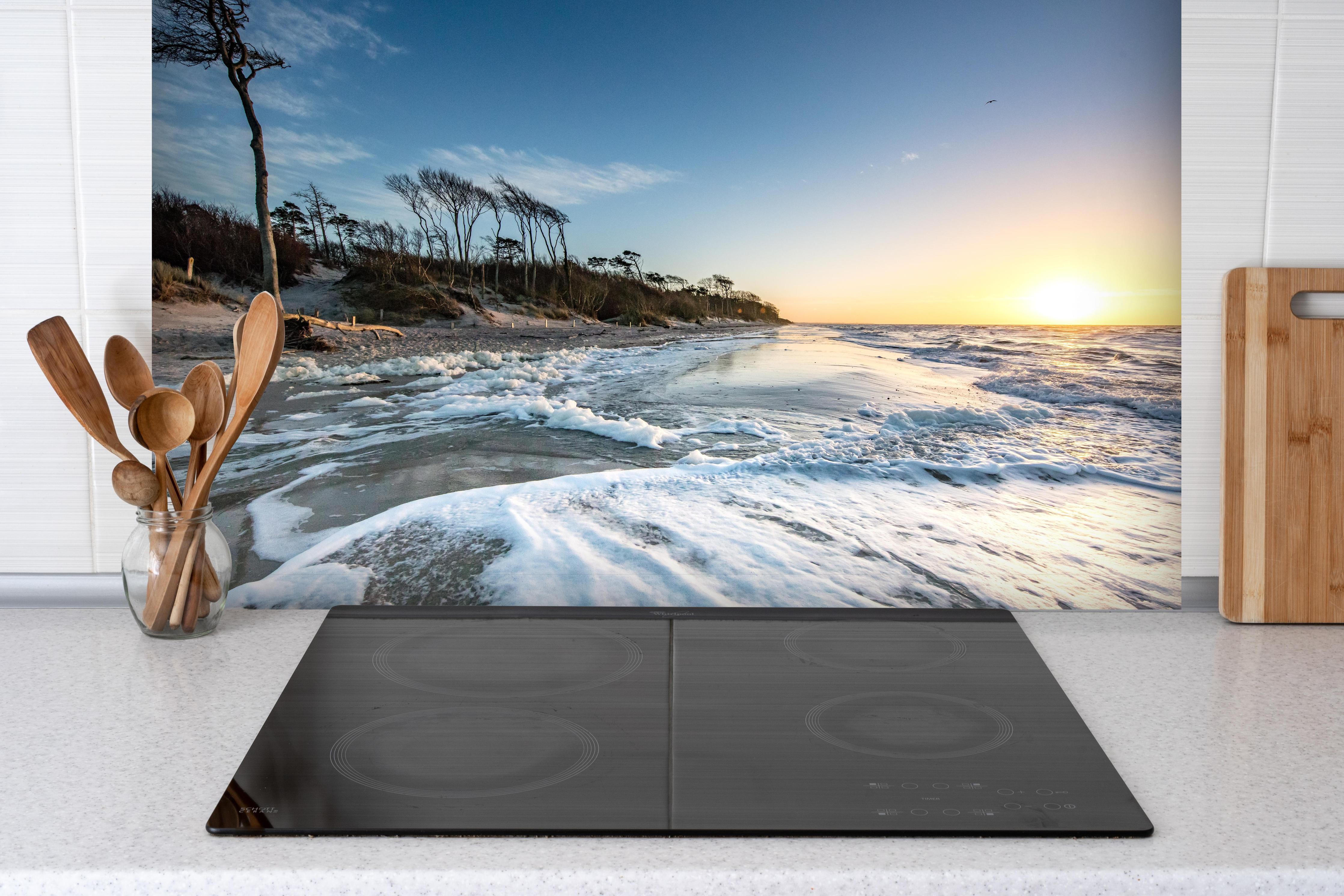 Spritzschutz - Strand in Rügen bei Sonnenaufgang hinter einem Cerankochfeld zwischen Holz-Kochutensilien