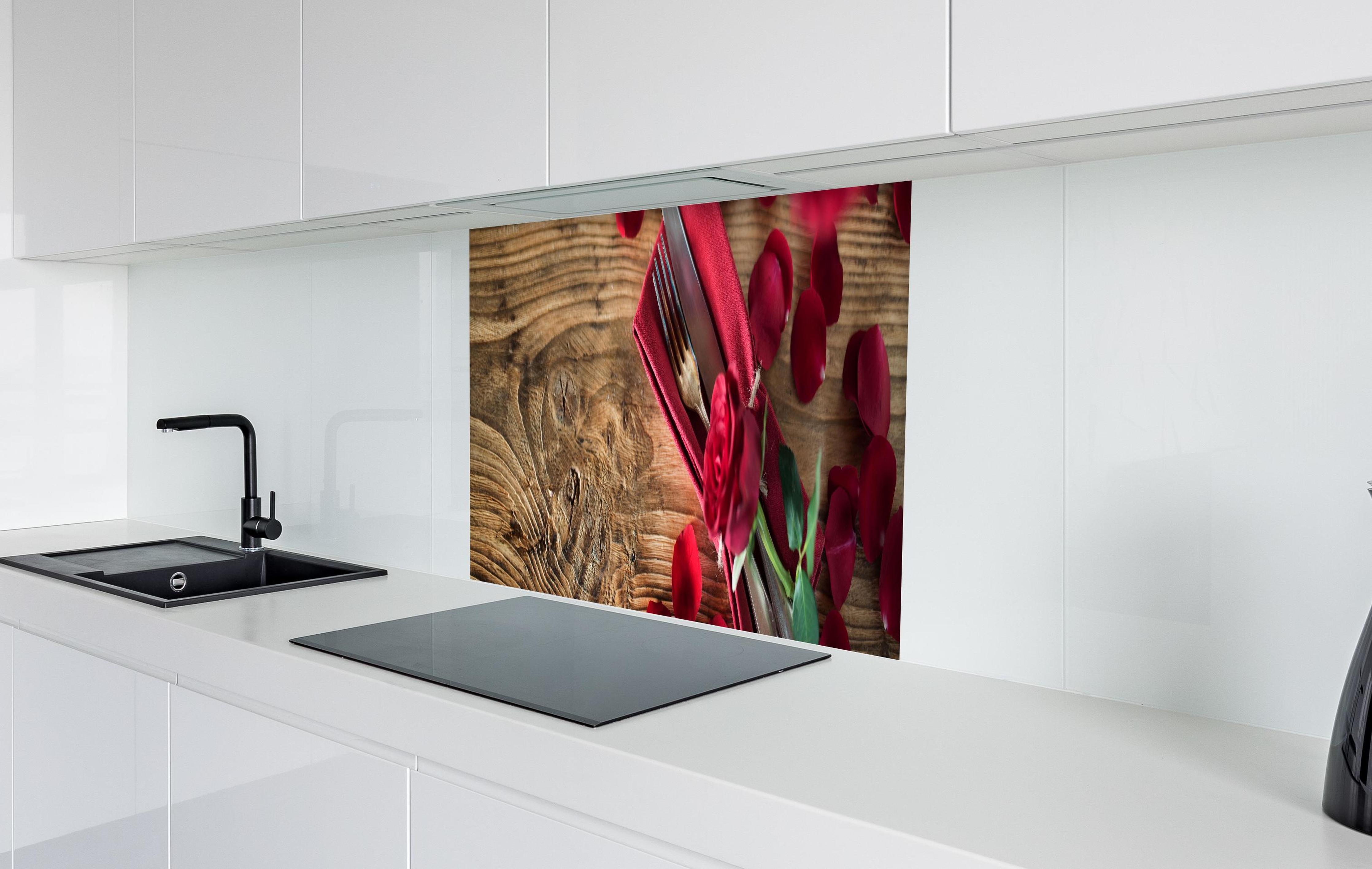 Spritzschutz - Tischdekoration mit roten Rosen in weißer Hochglanz-Küche hinter einem Cerankochfeld