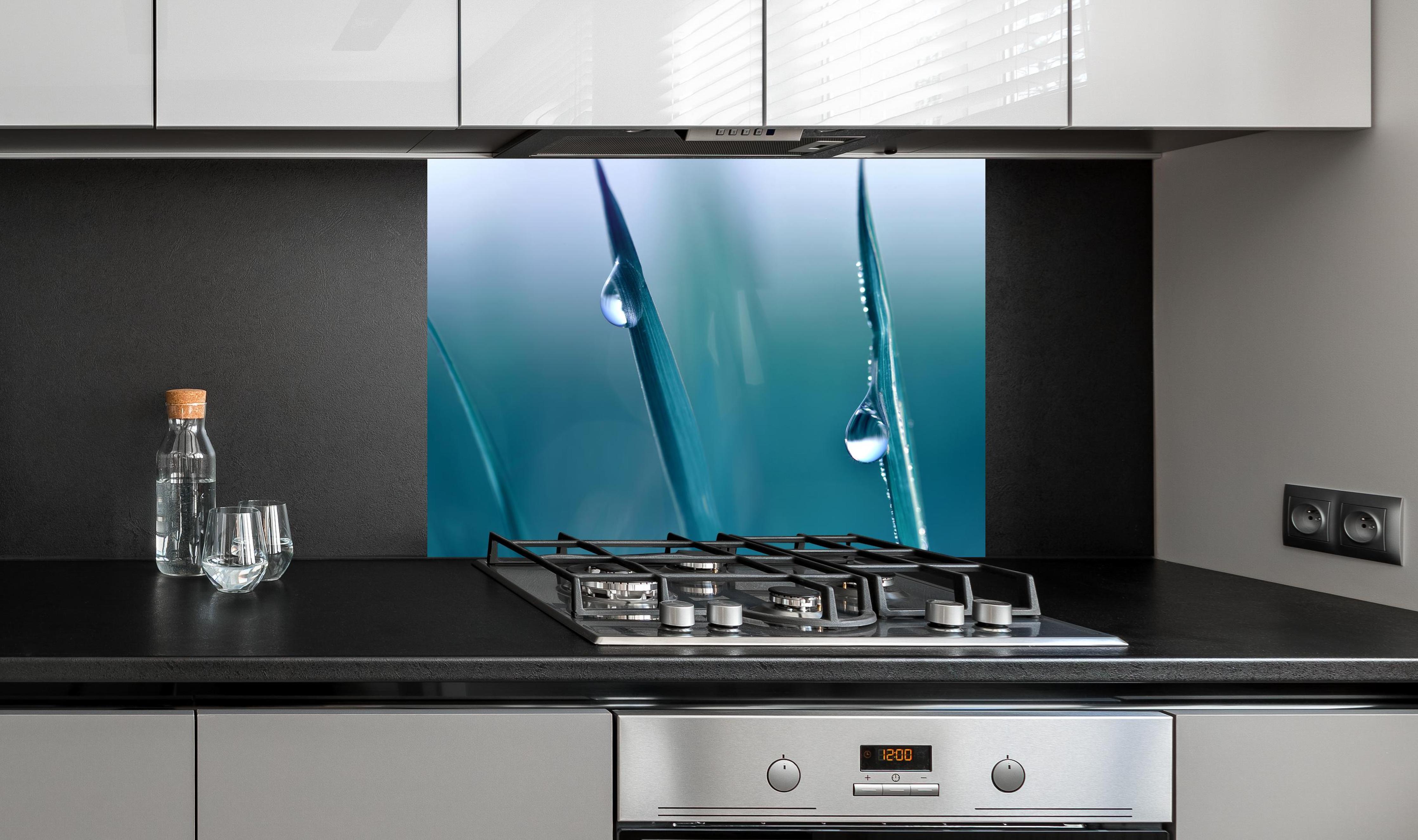 Spritzschutz - Transparente Tautropfen an edler Anthrazit-Wand hinter silbernem Gasherd