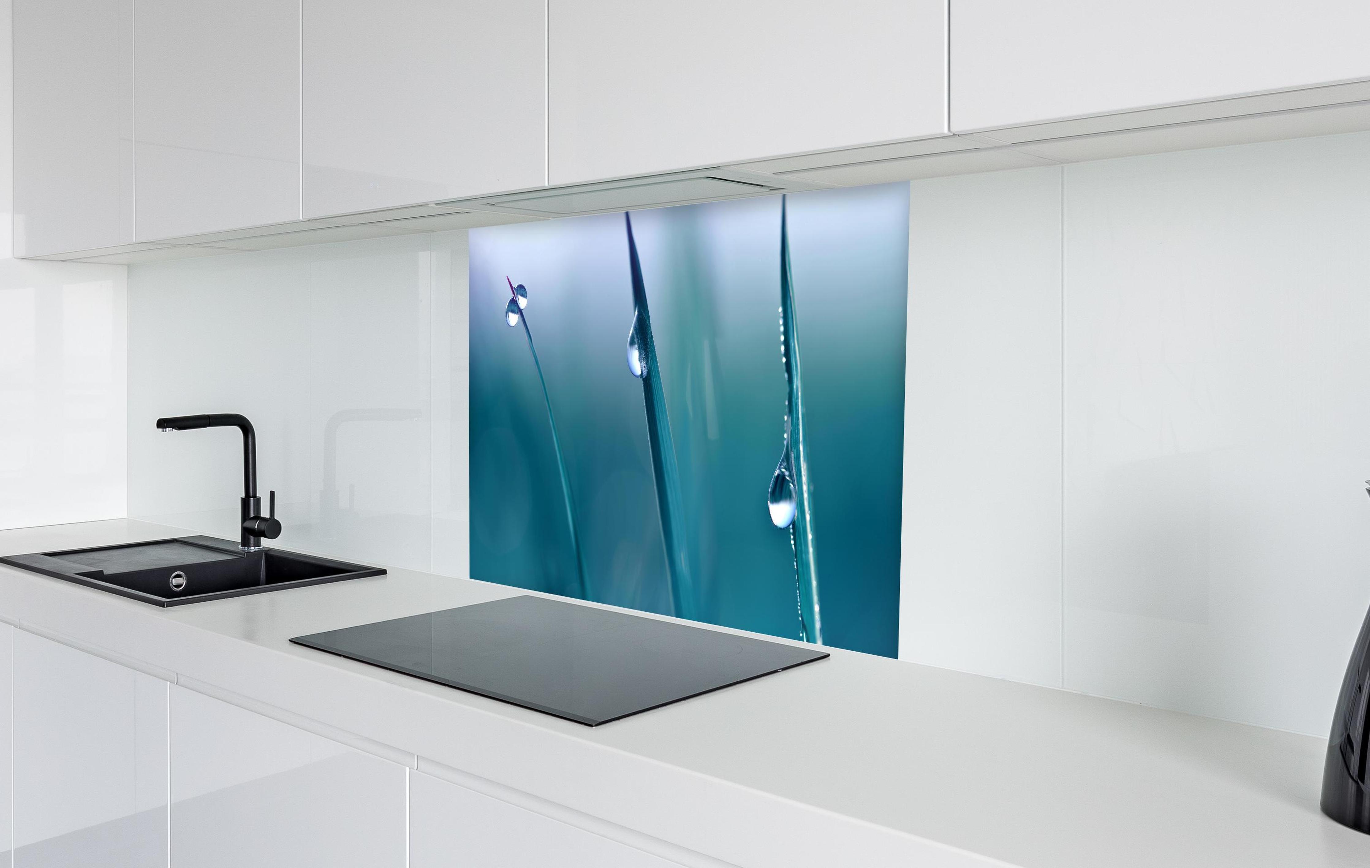 Spritzschutz - Transparente Tautropfen in weißer Hochglanz-Küche hinter einem Cerankochfeld