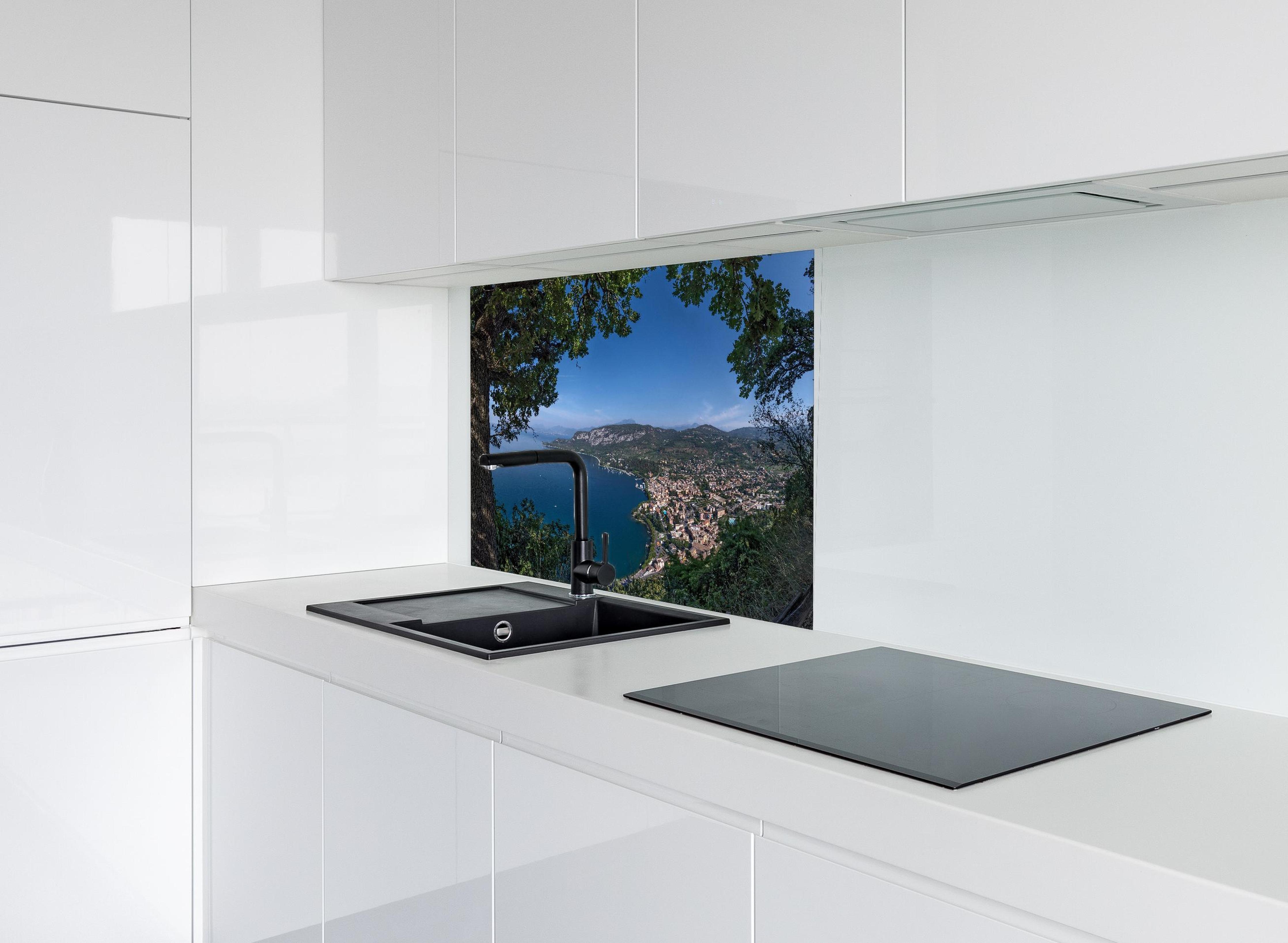 Spritzschutz - Traumhafter Ausblick auf Gardasee Italien hinter modernem schwarz-matten Spülbecken in weißer Hochglanz-Küche