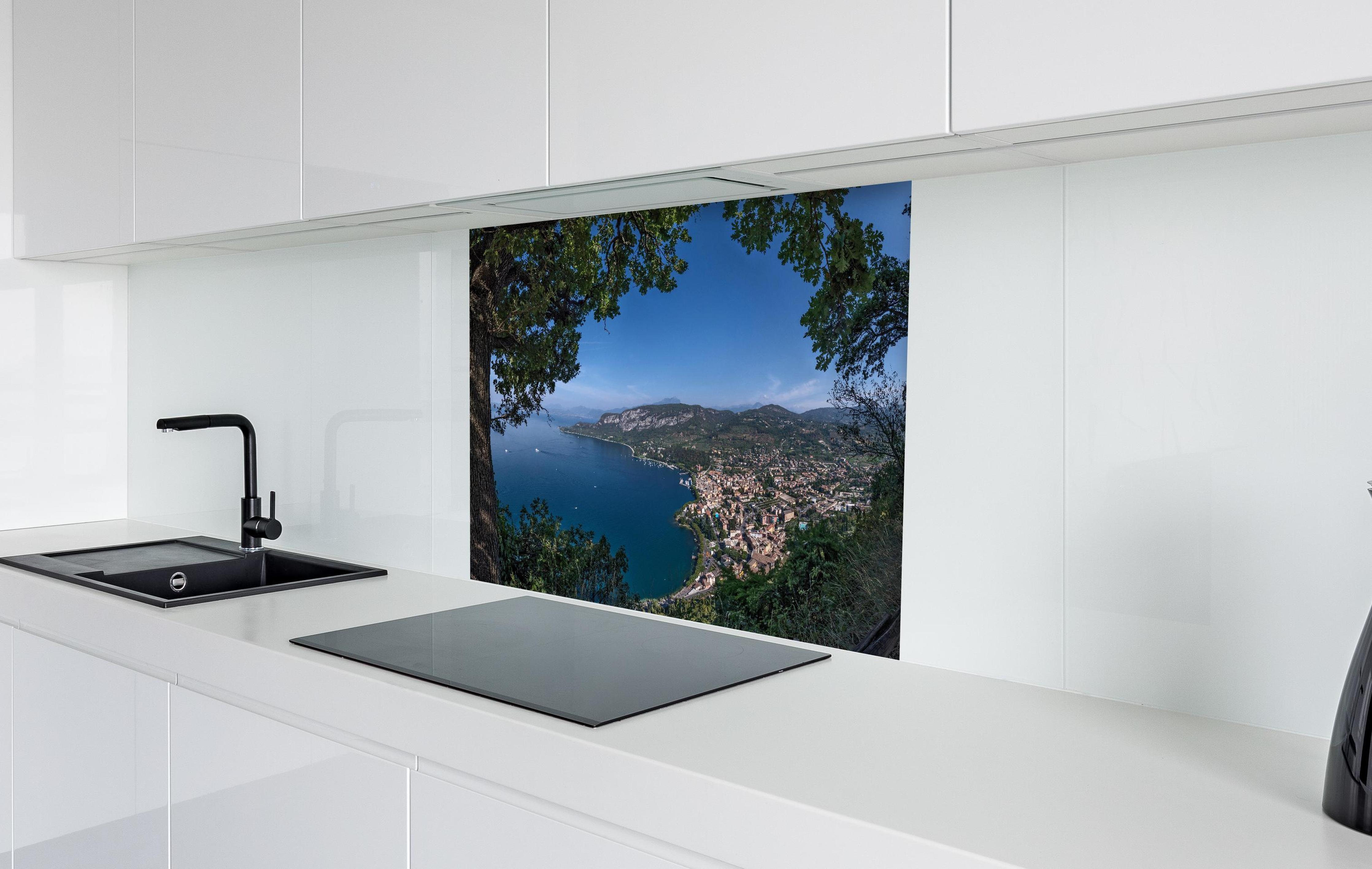 Spritzschutz - Traumhafter Ausblick auf Gardasee Italien in weißer Hochglanz-Küche hinter einem Cerankochfeld