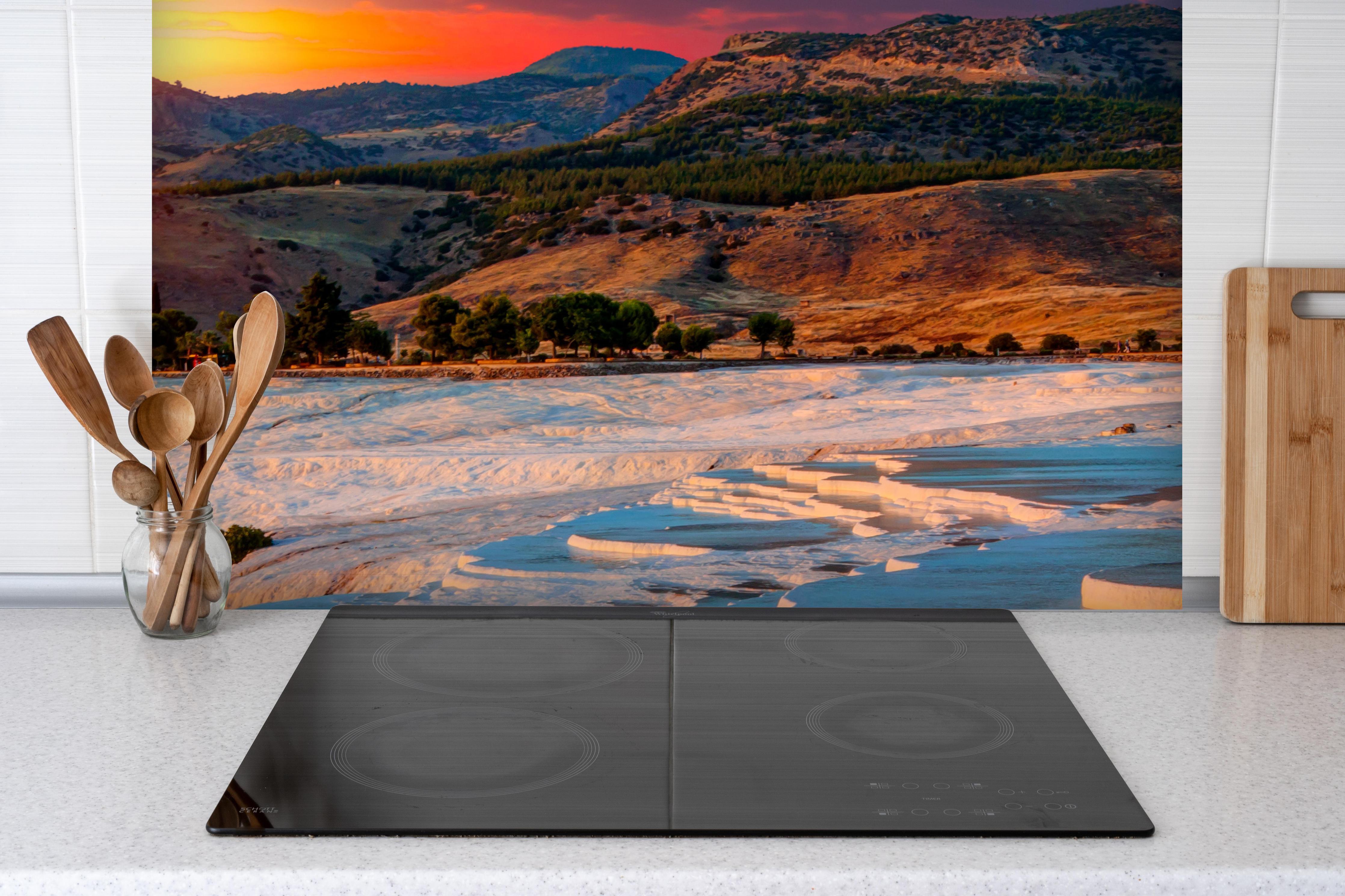 Spritzschutz - Travertinbecken in Pamukkale am Abend hinter einem Cerankochfeld zwischen Holz-Kochutensilien