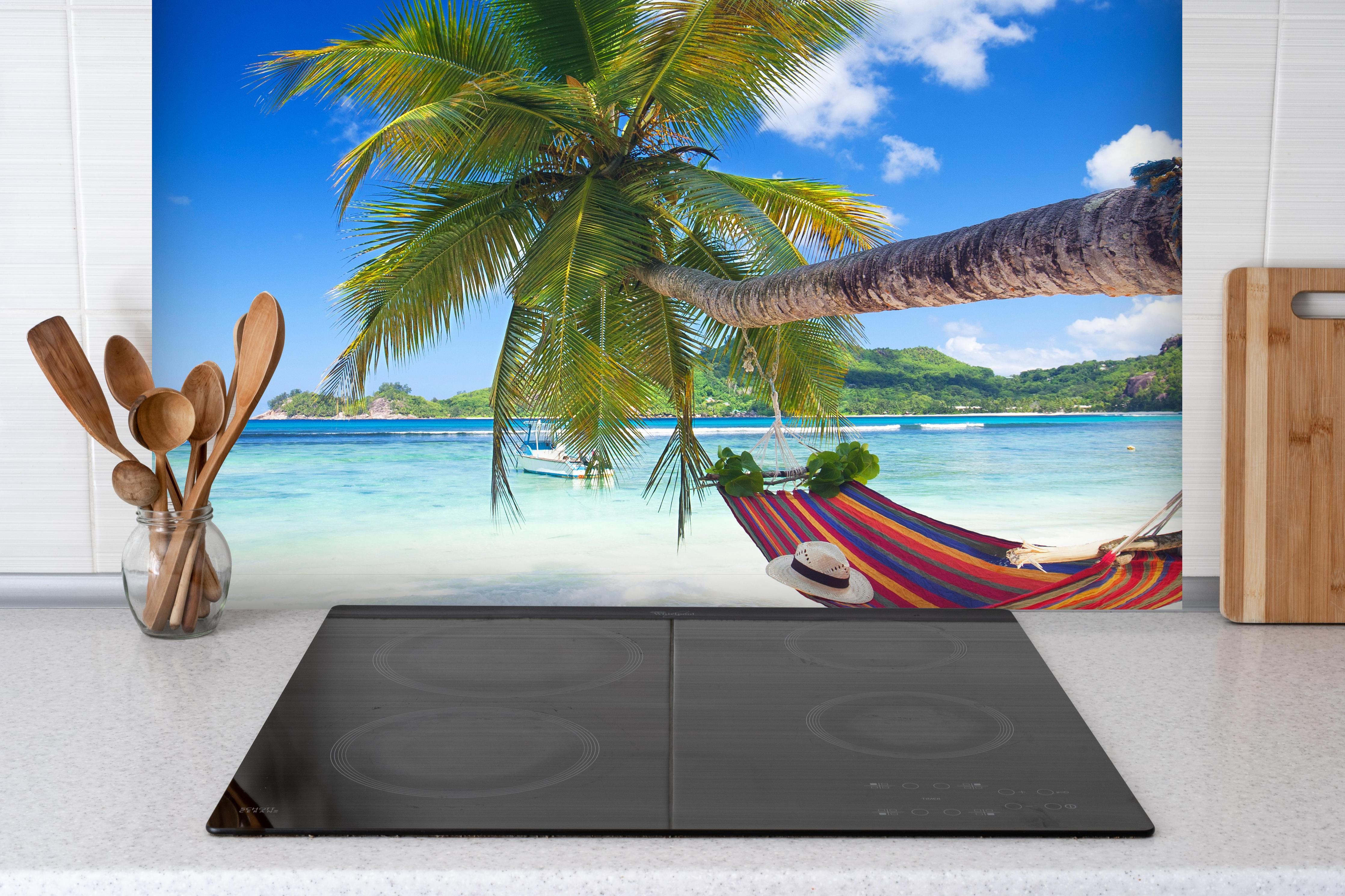 Spritzschutz - Urlaub am Strand in Seychellen hinter einem Cerankochfeld zwischen Holz-Kochutensilien