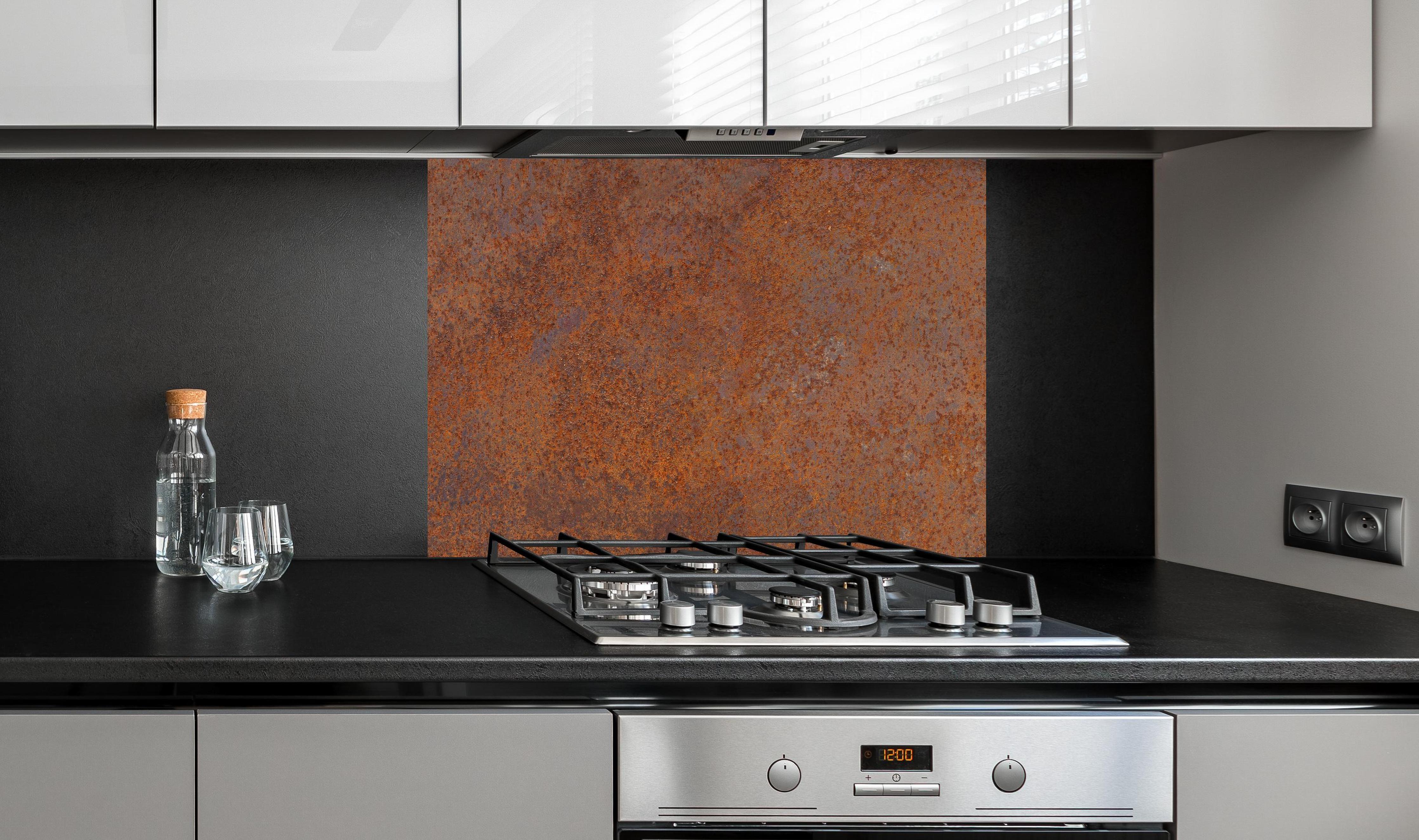 Spritzschutz - Verrostetes Metall an edler Anthrazit-Wand hinter silbernem Gasherd