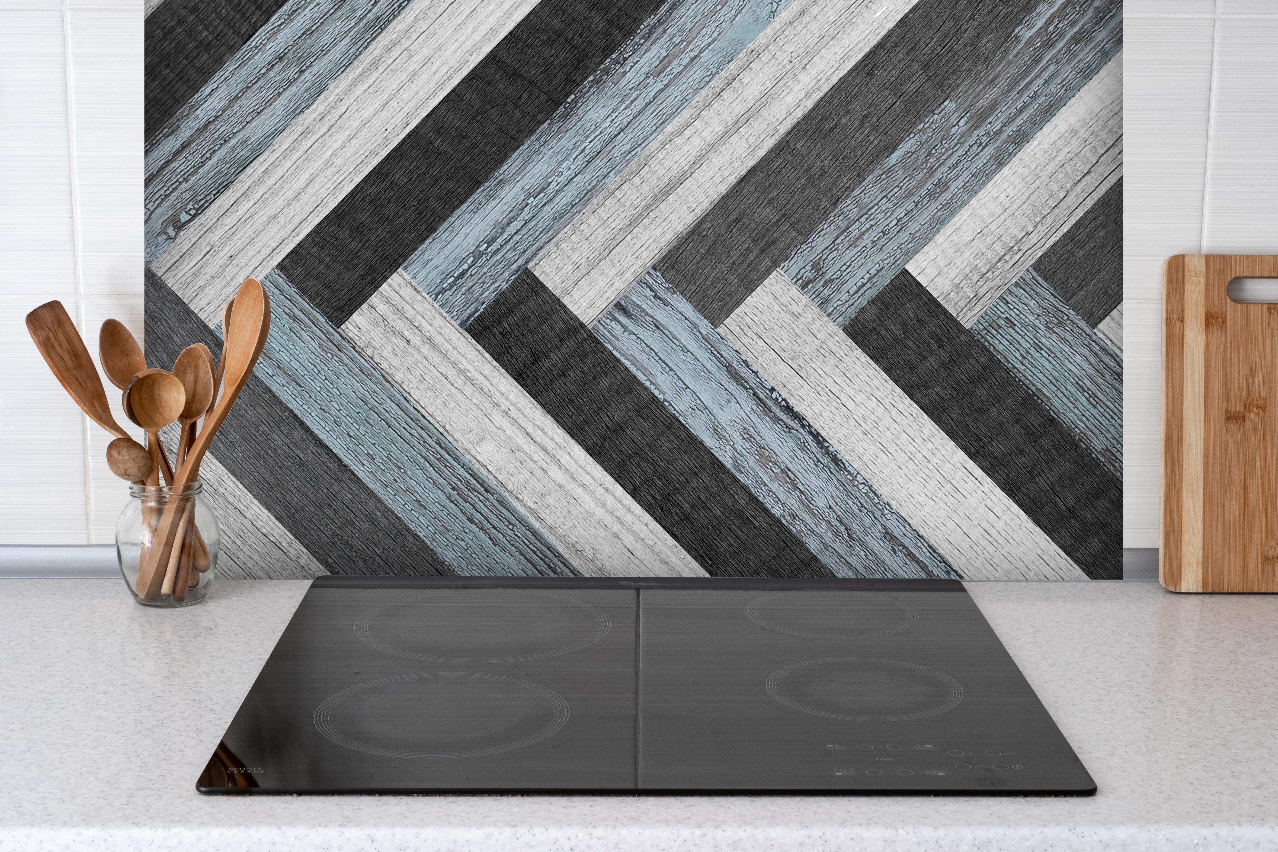 Spritzschutz - Verwitterte gemischte Holzdielen hinter einem Cerankochfeld zwischen Holz-Kochutensilien