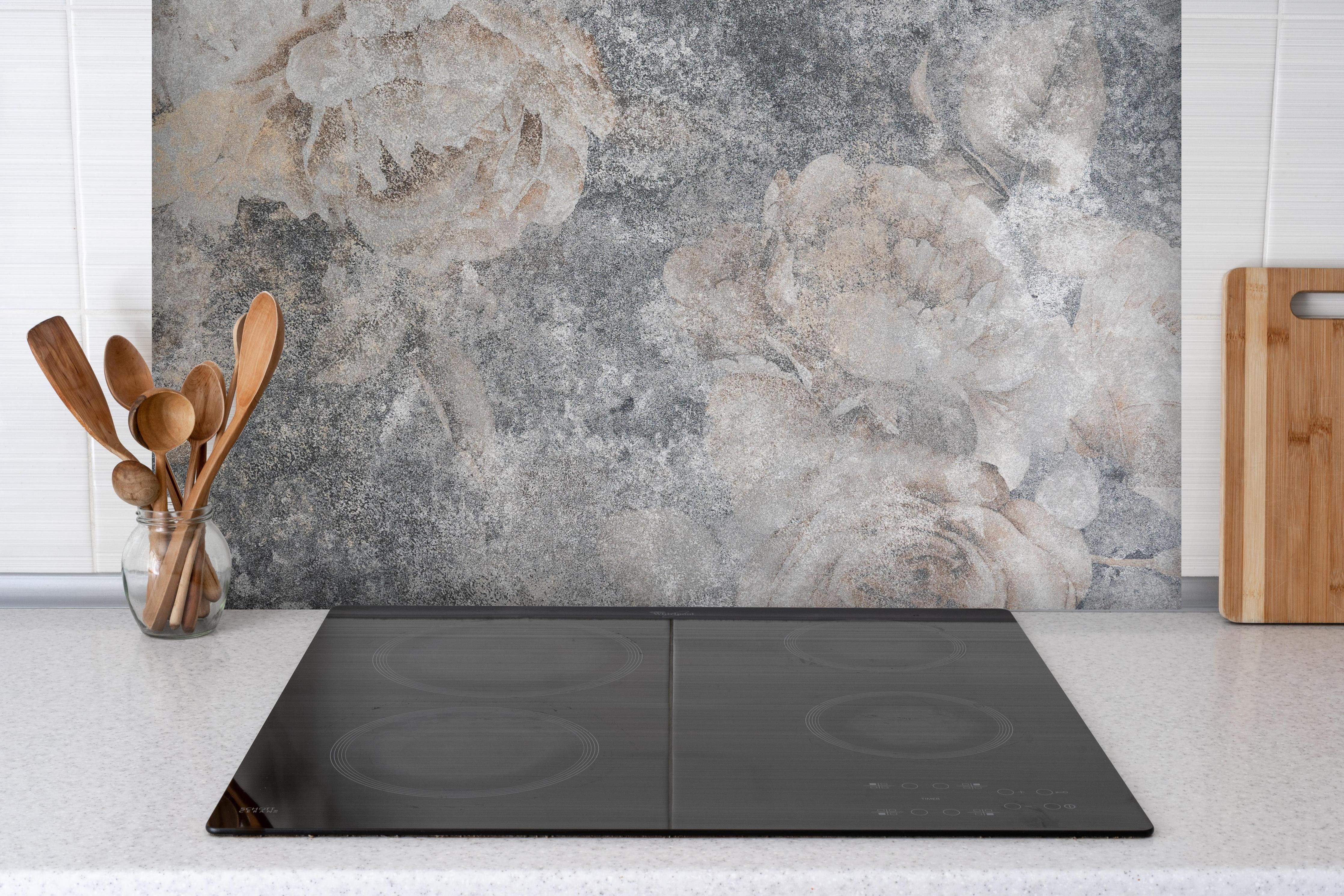 Spritzschutz - Vintage Rosenmuster hinter einem Cerankochfeld zwischen Holz-Kochutensilien