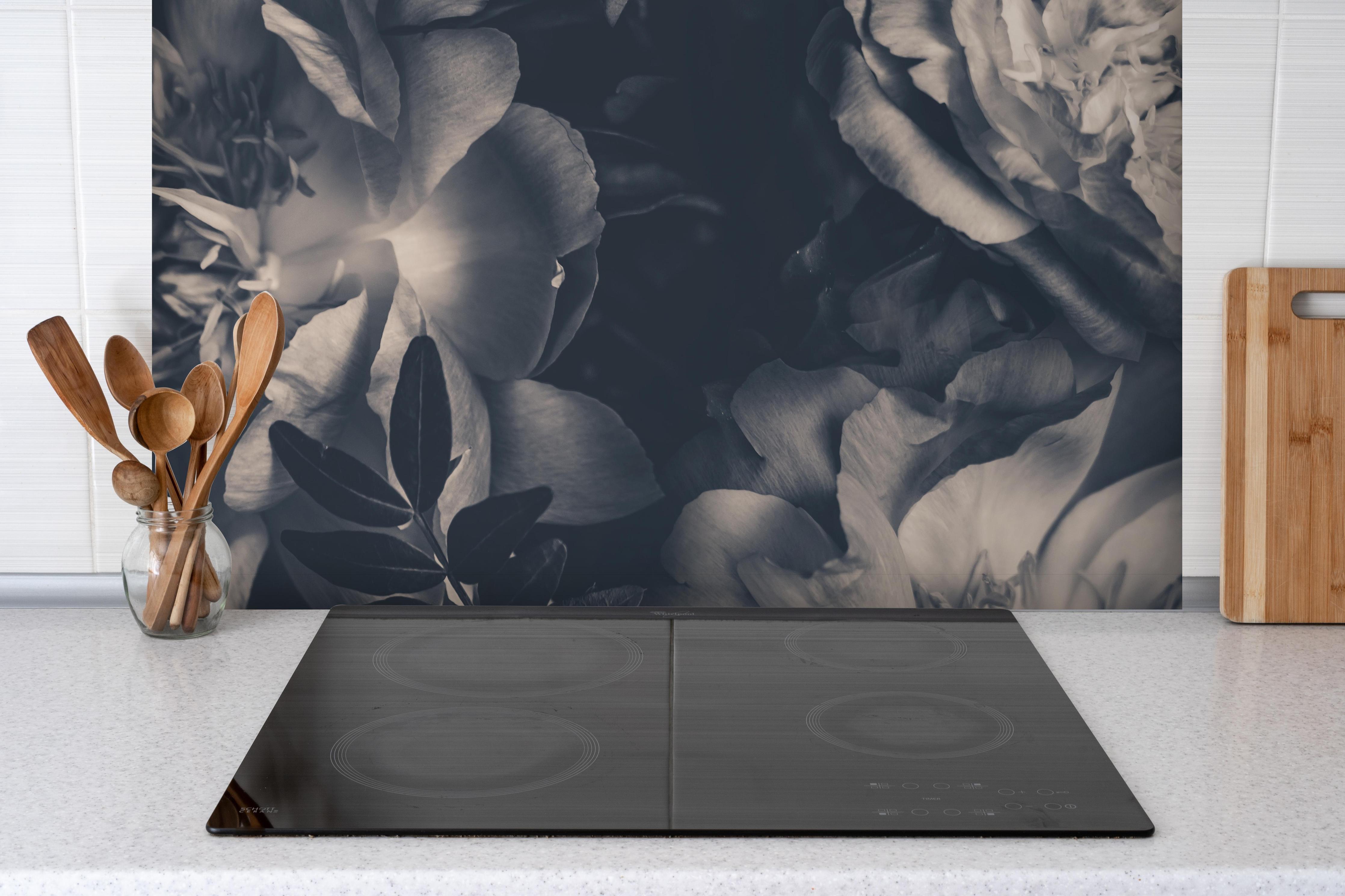 Spritzschutz - Vintage-Strauß aus Pfingstrosen hinter einem Cerankochfeld zwischen Holz-Kochutensilien