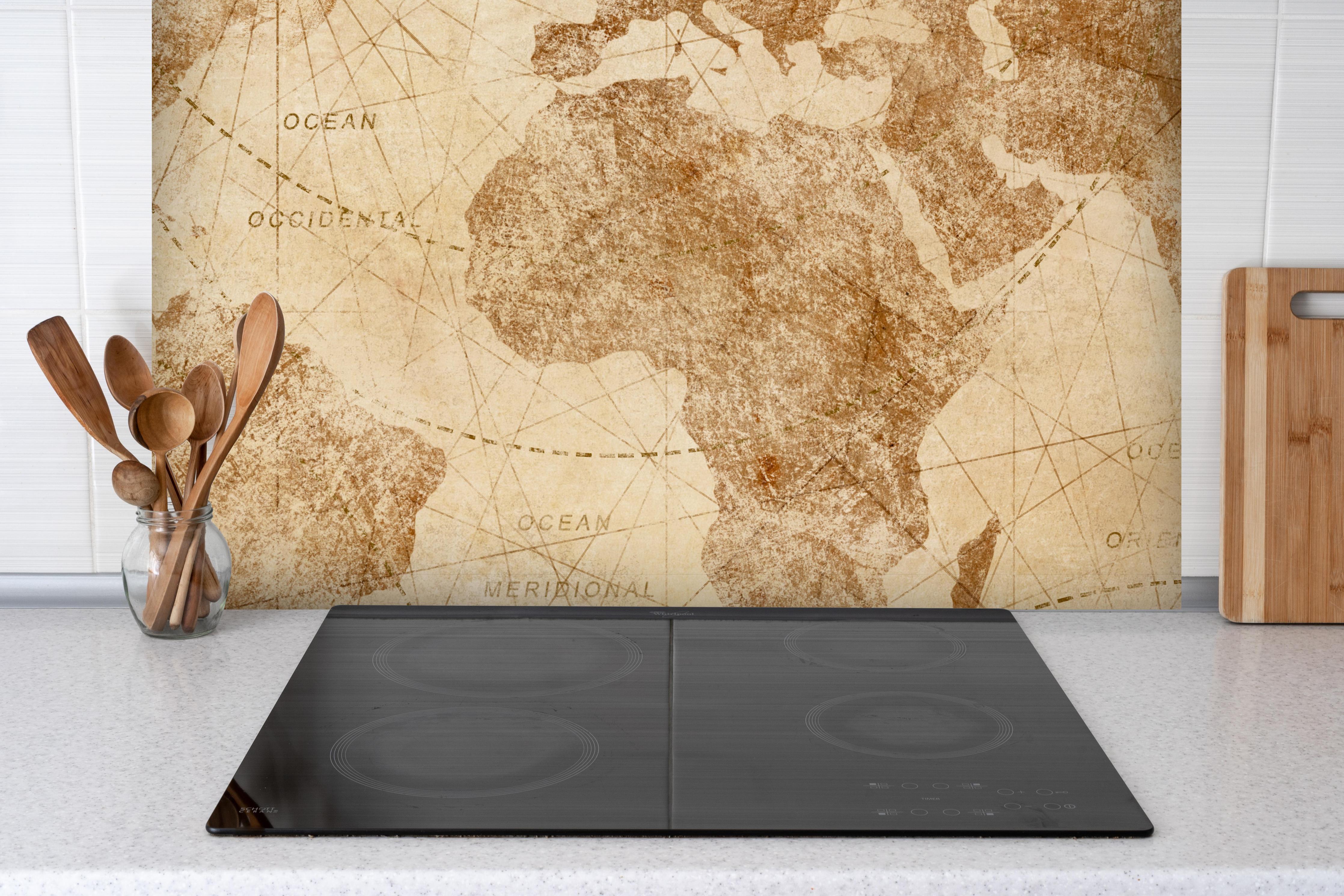 Spritzschutz - Vintage Weltkarte hinter einem Cerankochfeld zwischen Holz-Kochutensilien
