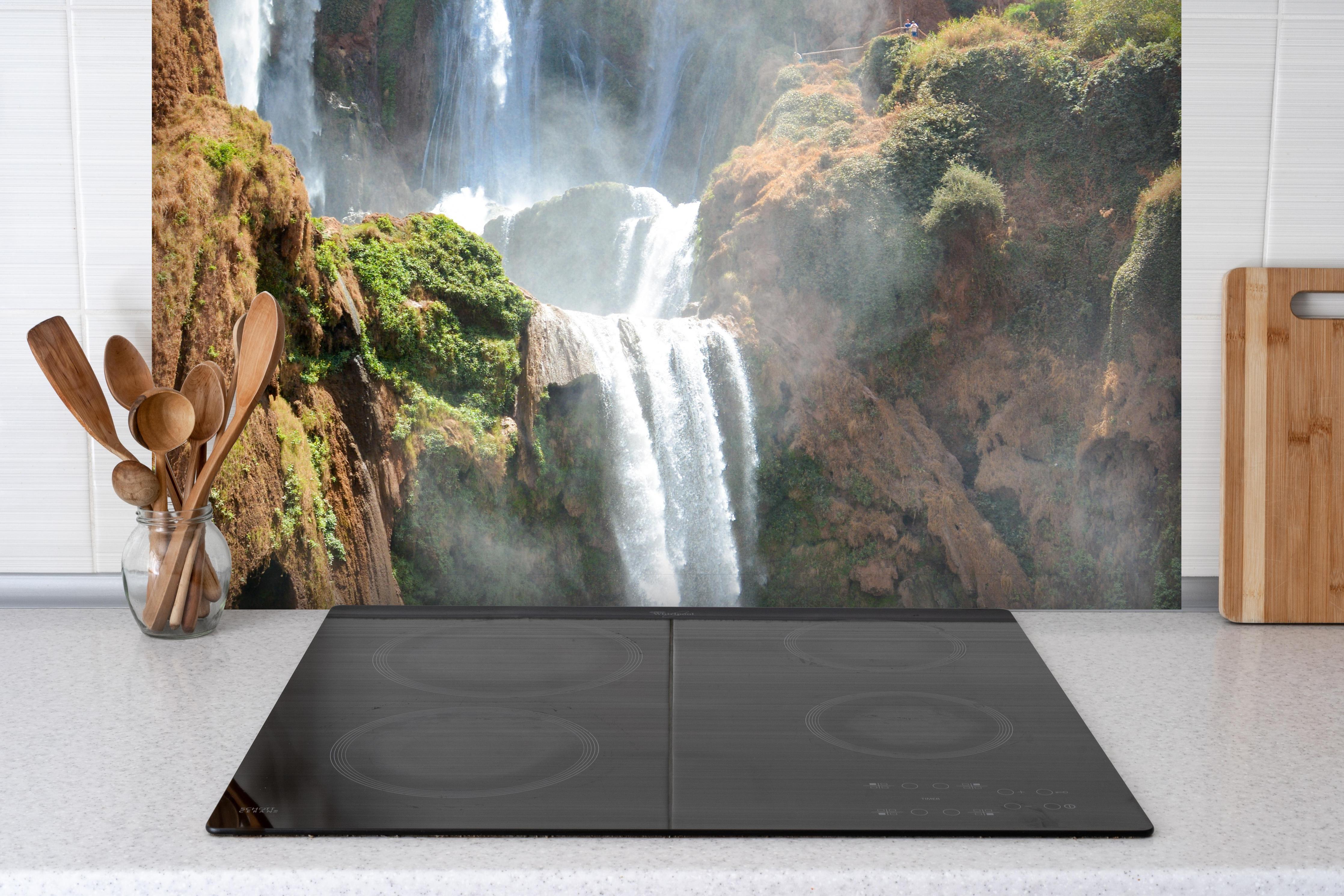 Spritzschutz - Wasserfälle von Ouzoud hinter einem Cerankochfeld zwischen Holz-Kochutensilien