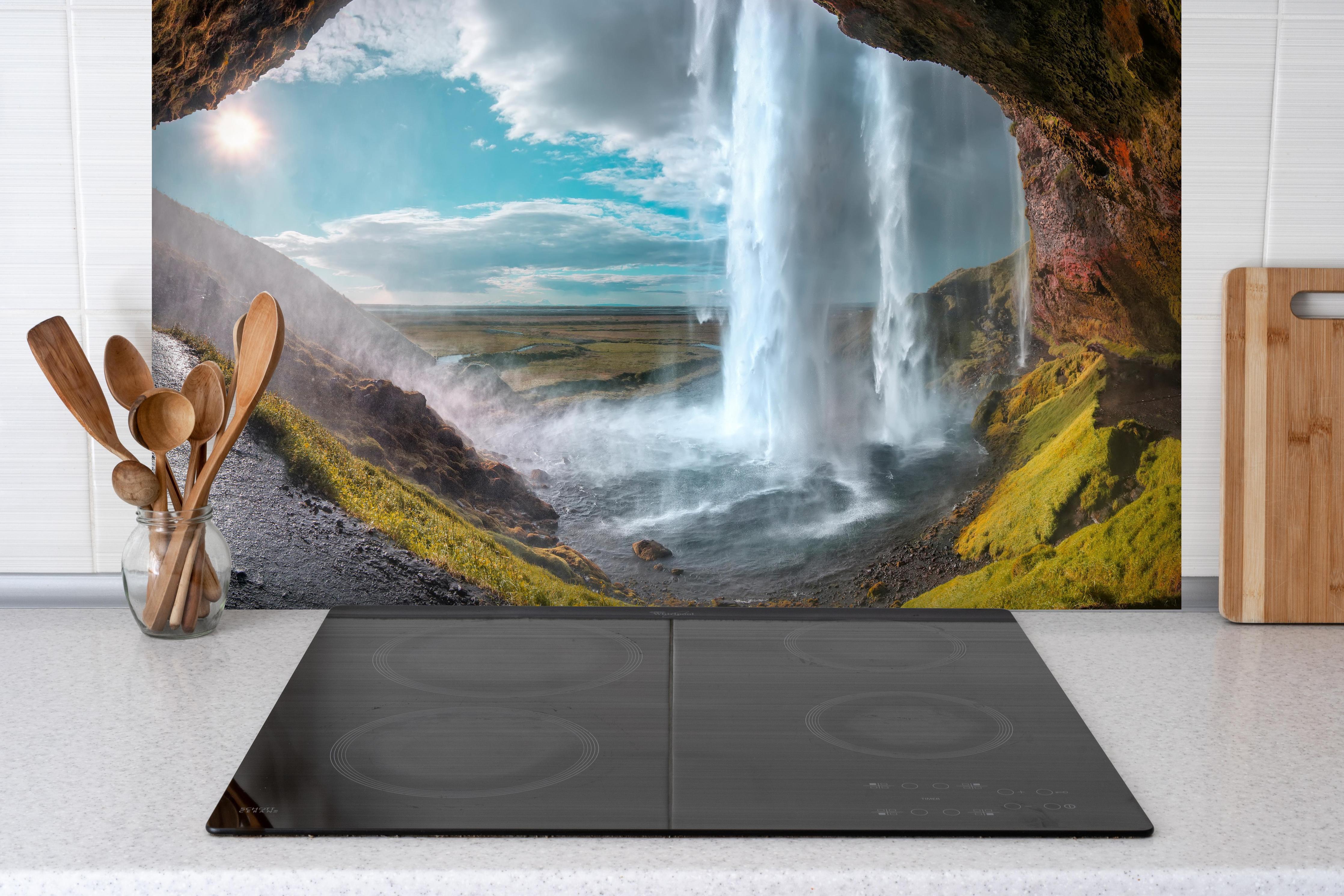 Spritzschutz - Wasserfall durch Bergtunnel hinter einem Cerankochfeld zwischen Holz-Kochutensilien