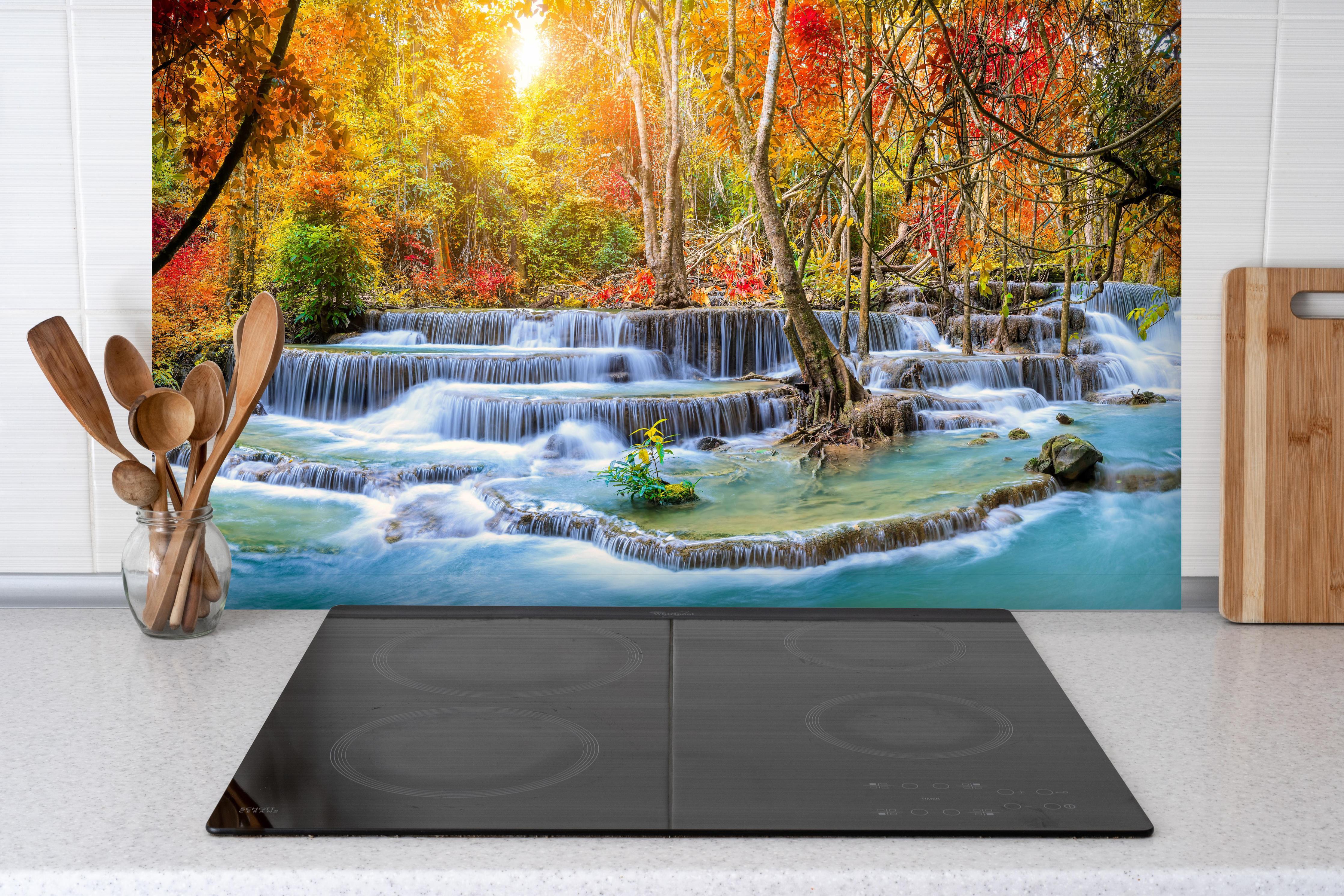 Spritzschutz - Wasserfall im Wald Thailand Nationalparks hinter einem Cerankochfeld zwischen Holz-Kochutensilien