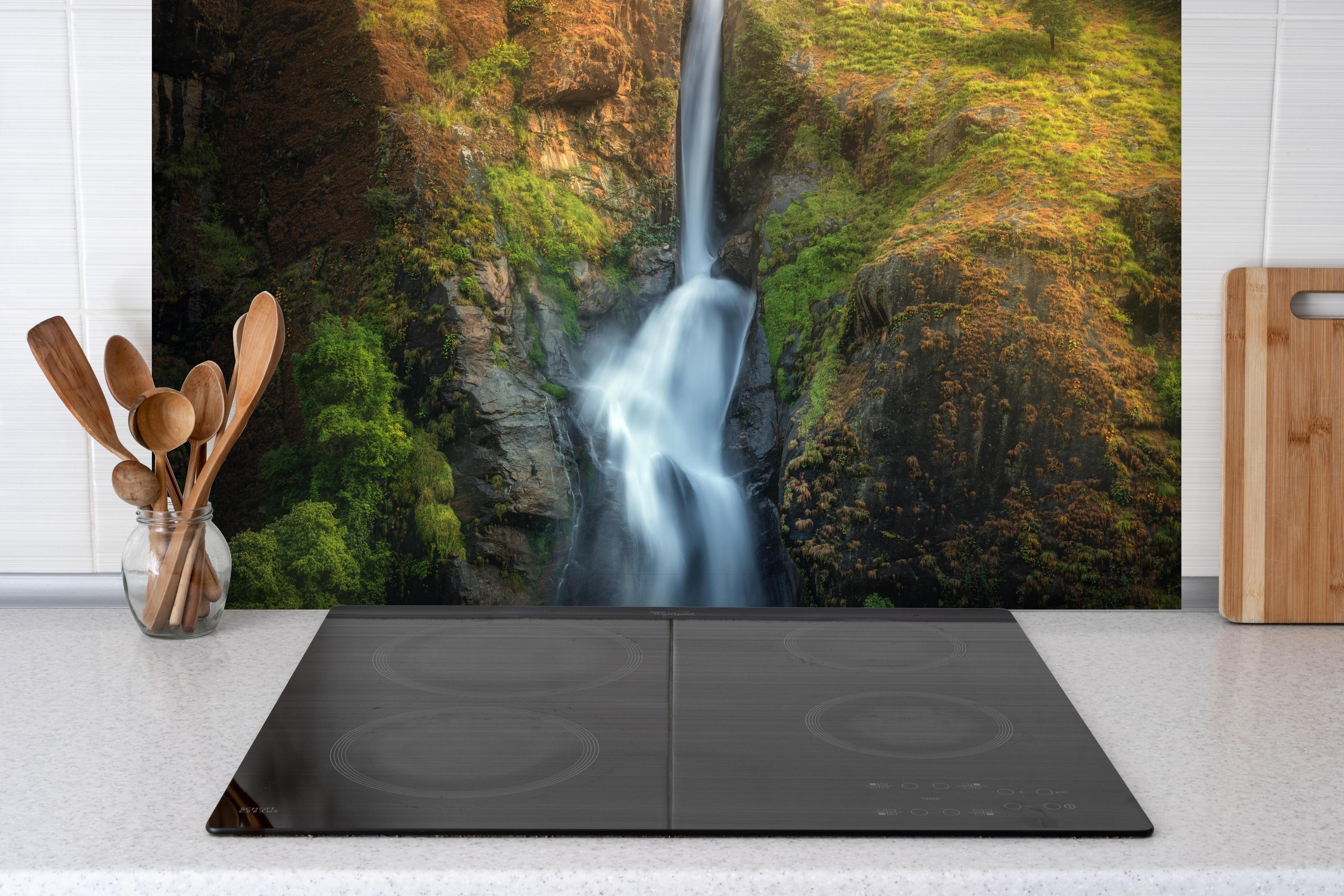Spritzschutz - Wasserfall im Wald von Nepal hinter einem Cerankochfeld zwischen Holz-Kochutensilien