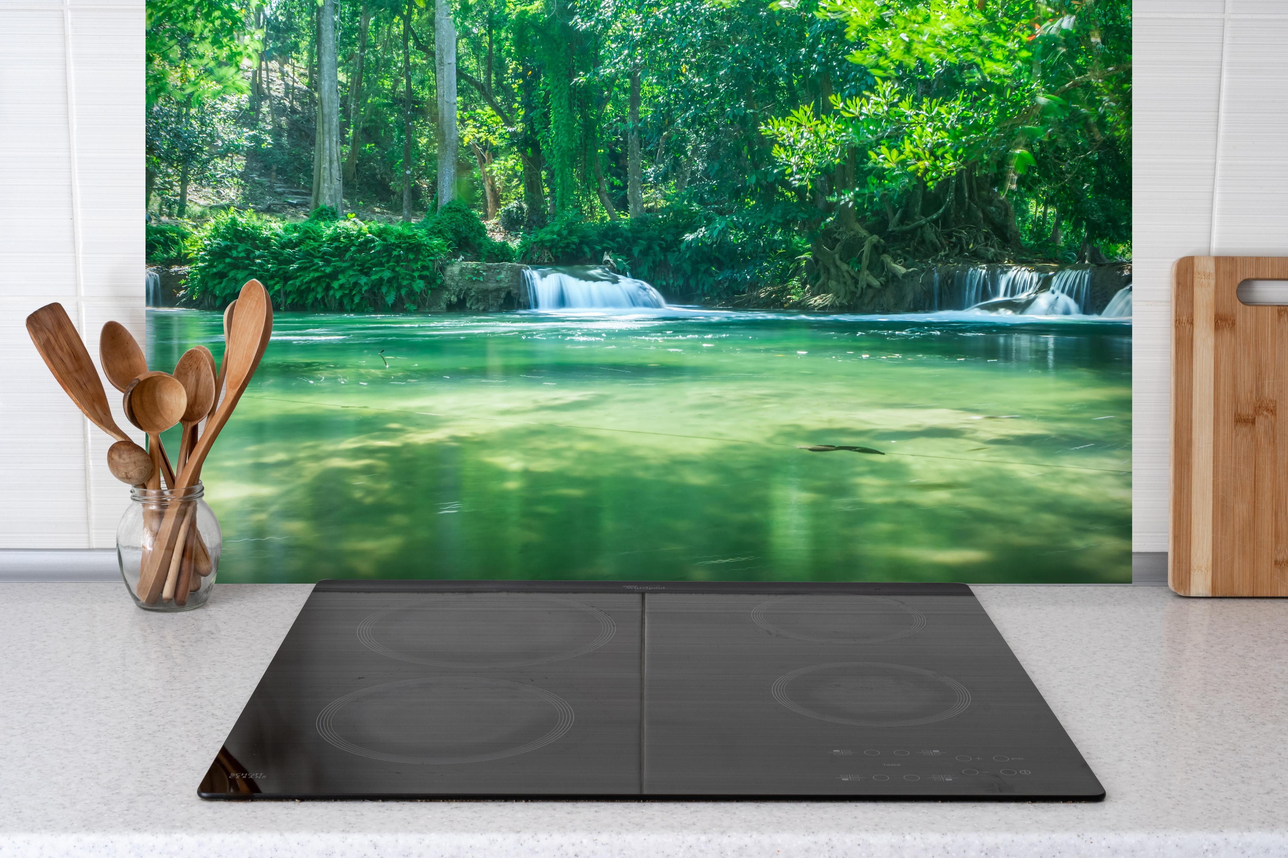 Spritzschutz - Wasserfall in Chet Sao No hinter einem Cerankochfeld zwischen Holz-Kochutensilien