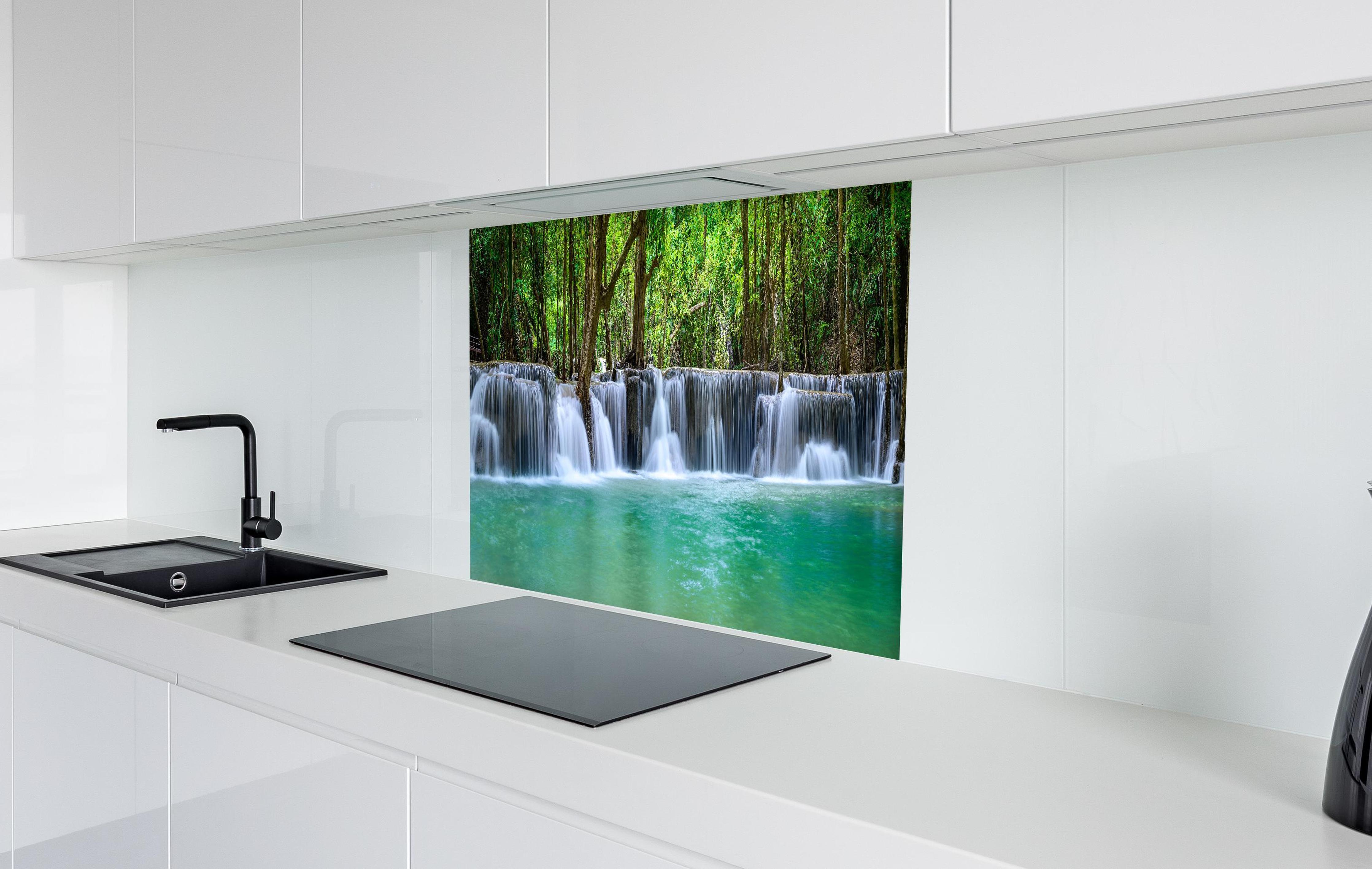 Spritzschutz - Wasserfall tief im tropischen Wald in weißer Hochglanz-Küche hinter einem Cerankochfeld